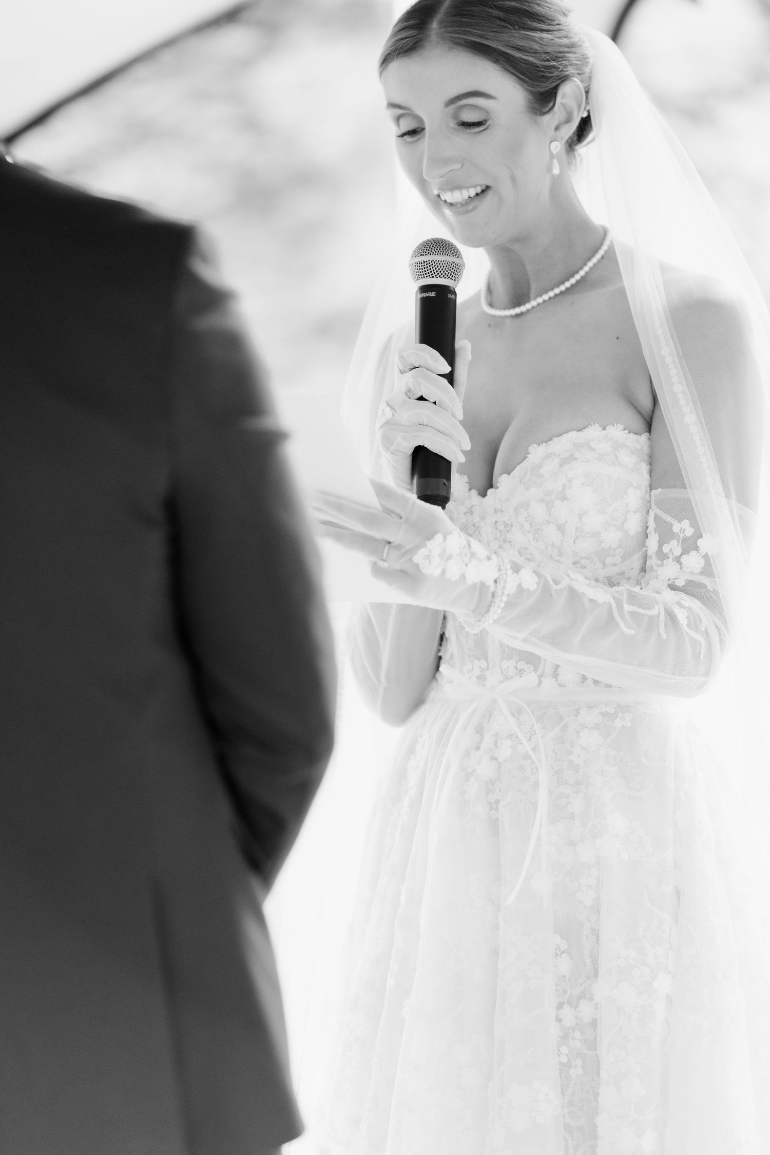 Black and white photos show close-up moments of a bride in a delicate lace wedding gown during the ceremony.
