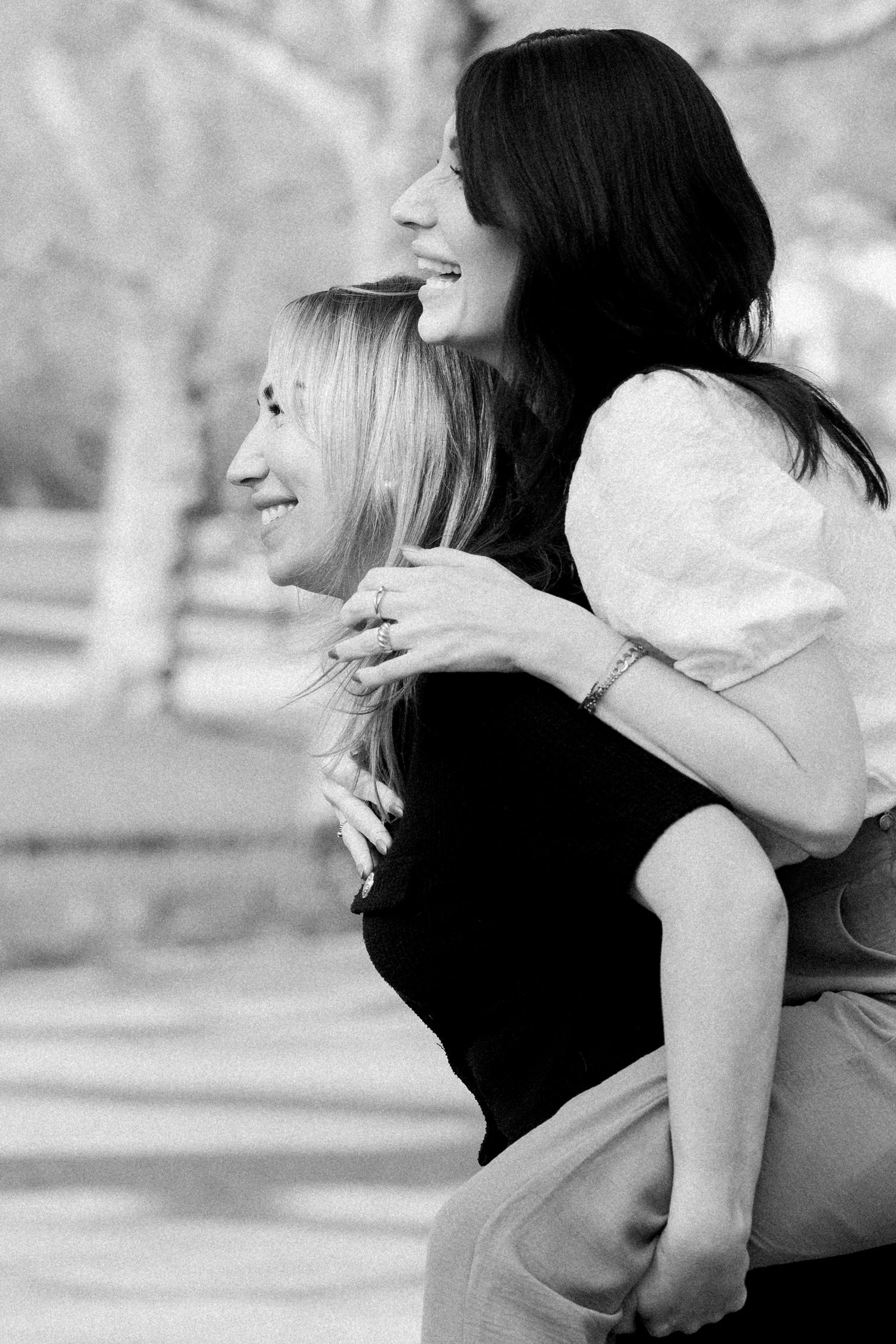 Black and white photo showing an intimate embrace between two people outdoors.