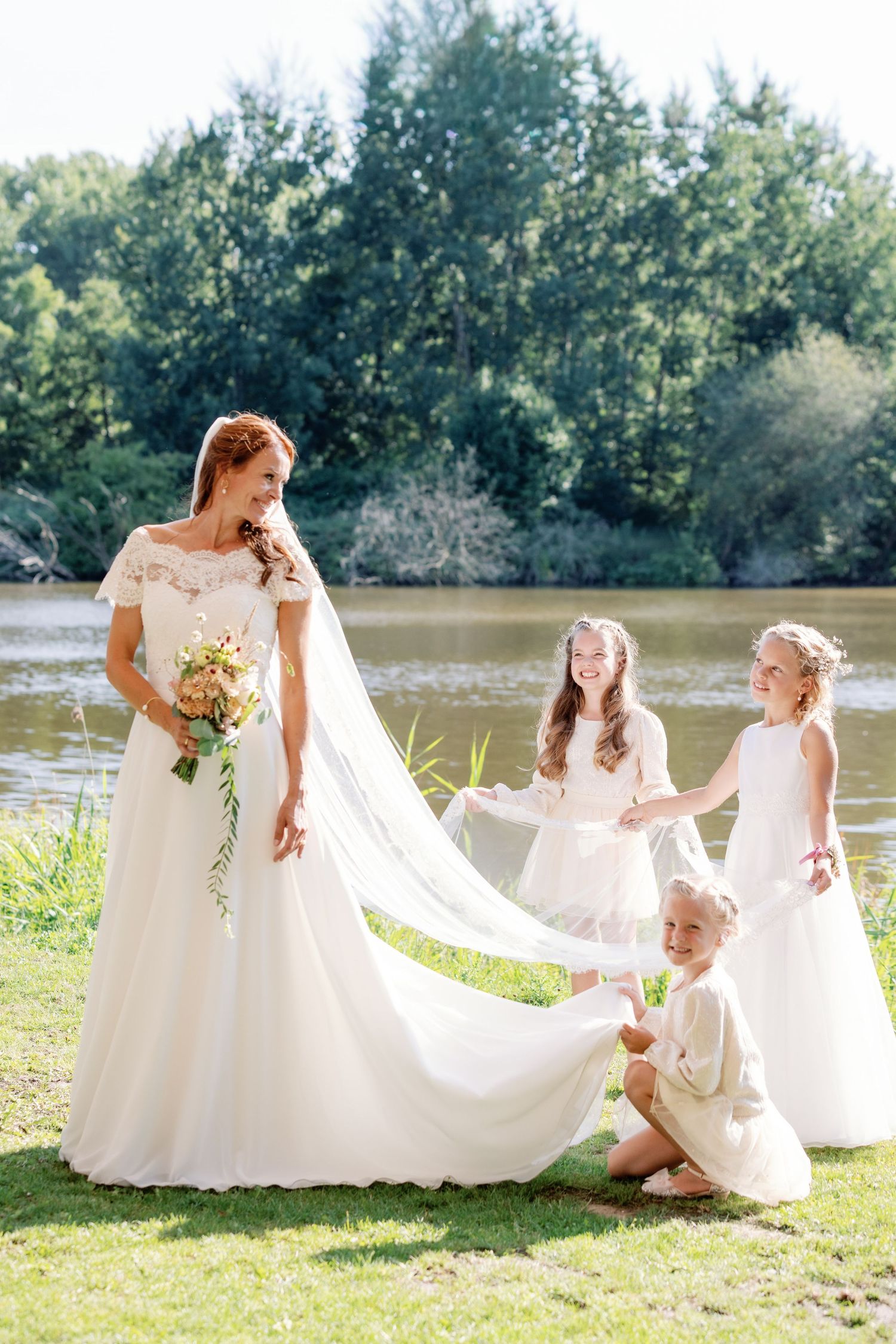 A series of candid moments in white dresses by a lakeside on a sunny summer day with lush greenery in the background.