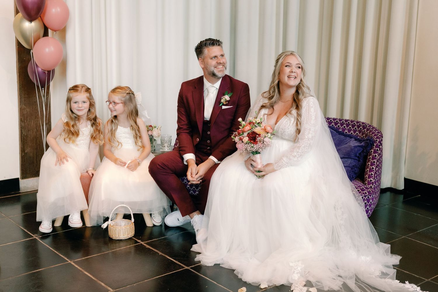 Wedding party members share joyful laughter during formal reception celebration.