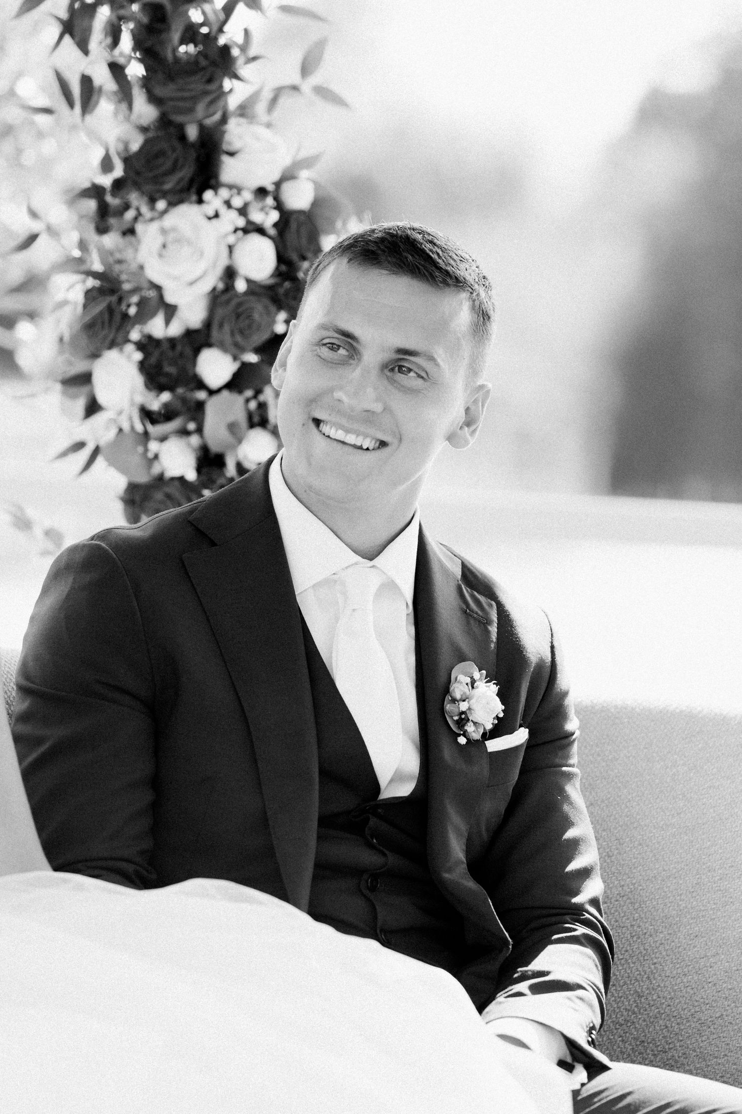 Black and white portraits of a groom in a dark suit and tie.
