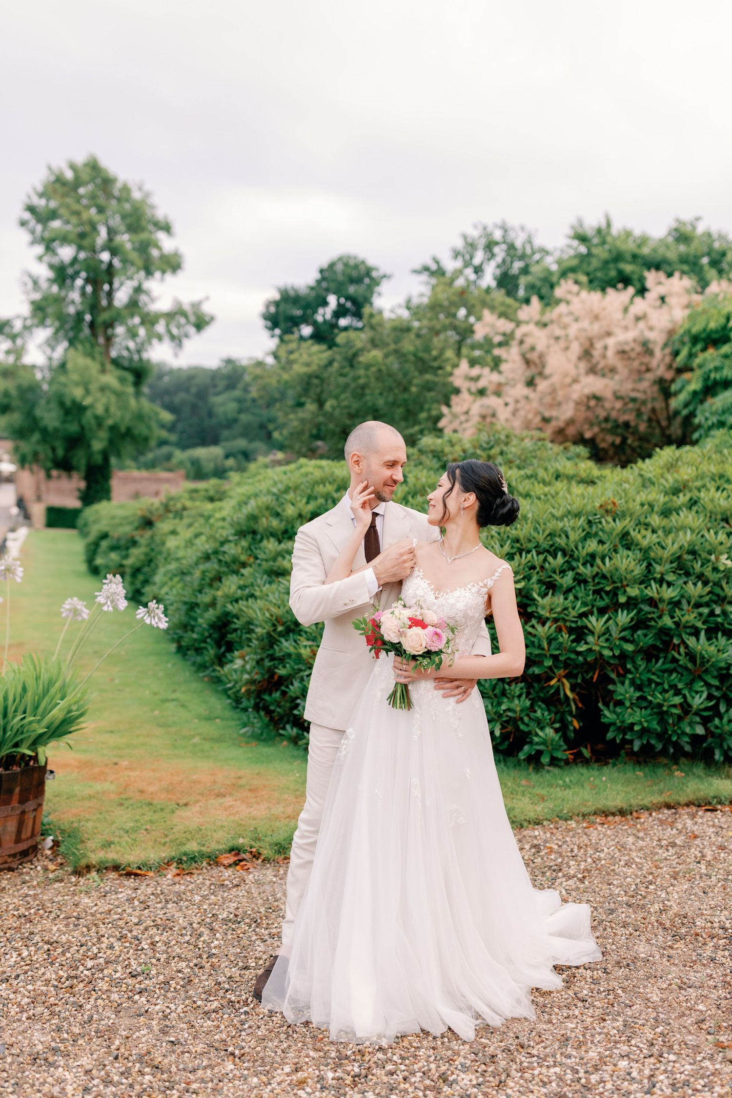 Newlyweds share joyful moments together on their wedding day in a beautiful garden setting.