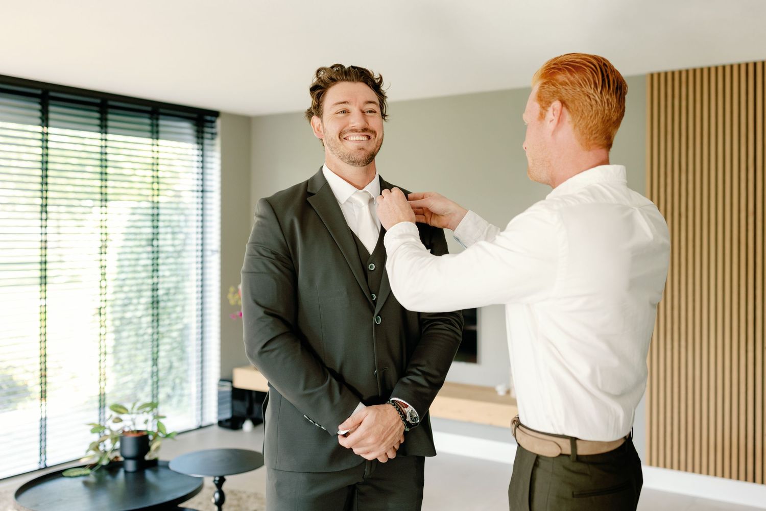 Business professionals in suits greet each other with handshakes in a modern office setting.