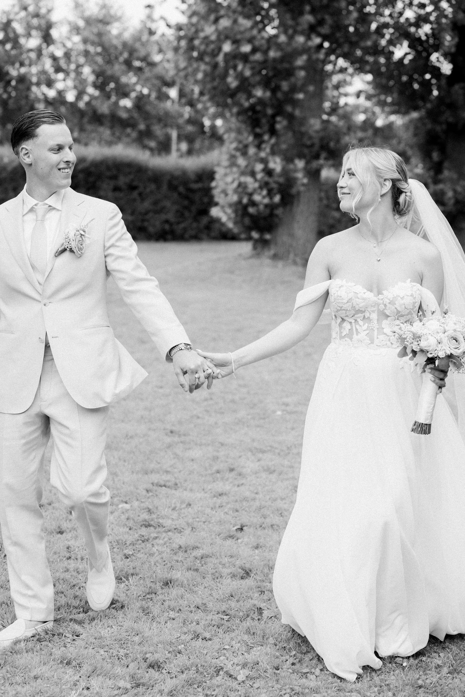 Black and white photo series of a couple dancing and twirling in wedding attire on a lawn.