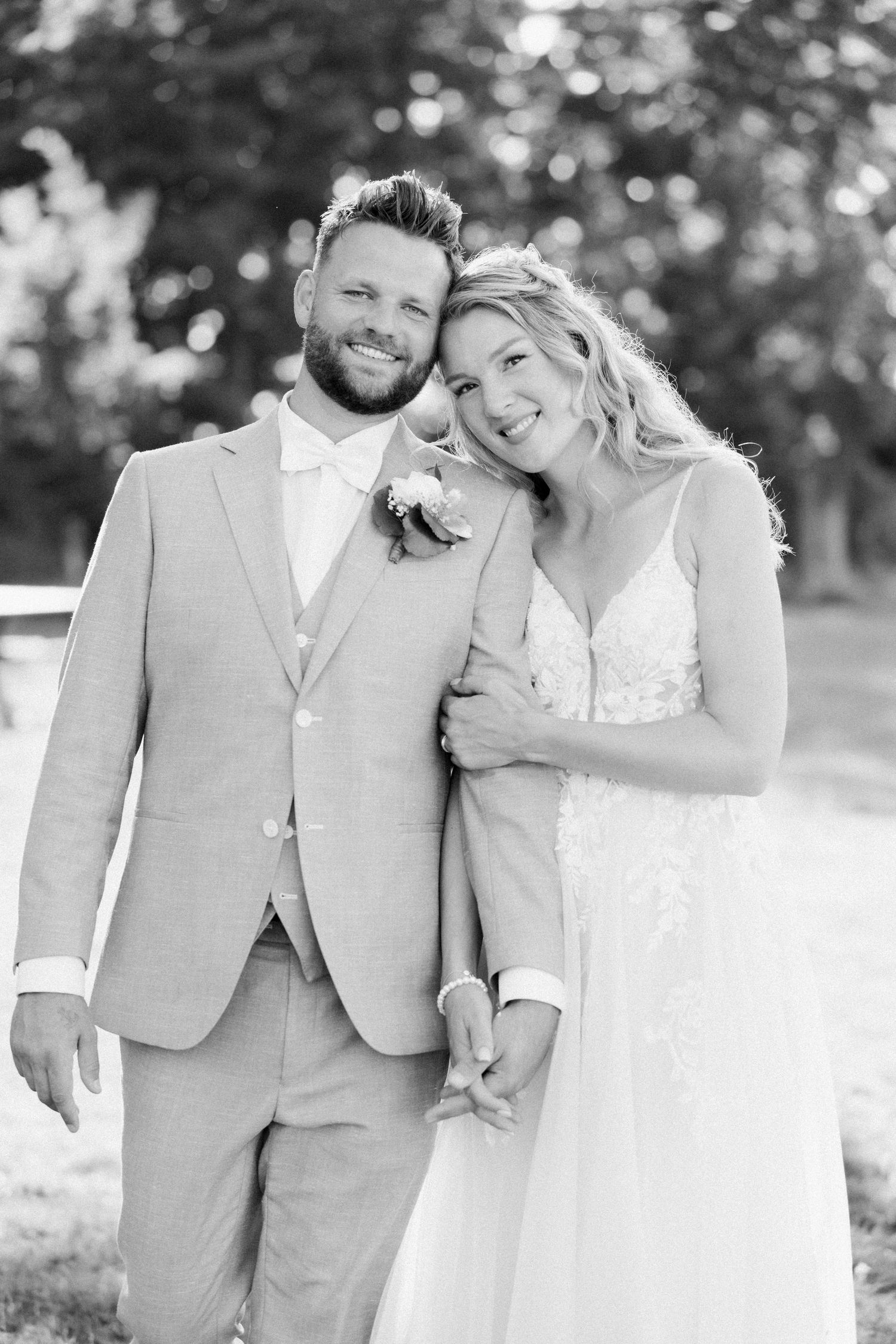 Black and white wedding photos showing joyful moments between a couple in formal attire outdoors.