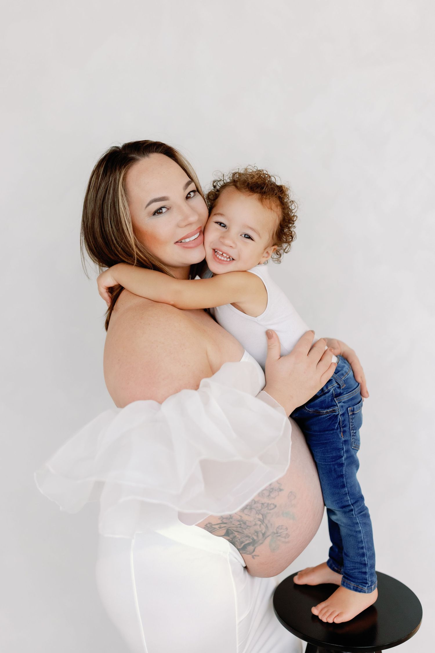 A tender moment captured in a series of black and white studio portraits showing affection and connection.