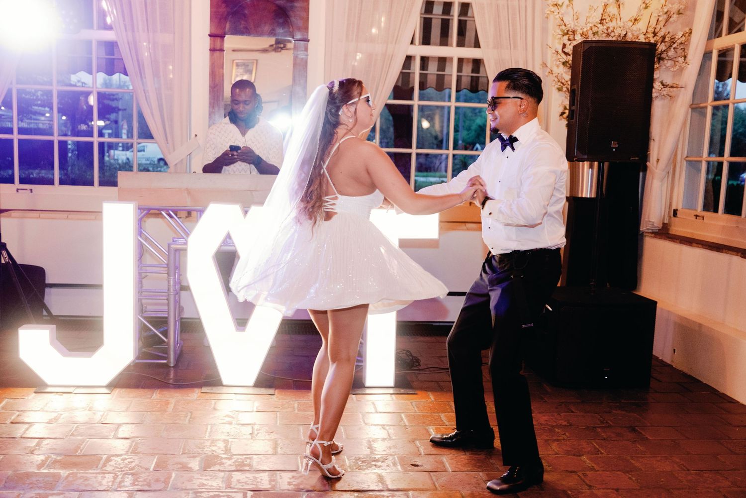 Large illuminated LOVE letters displayed at an evening wedding reception.