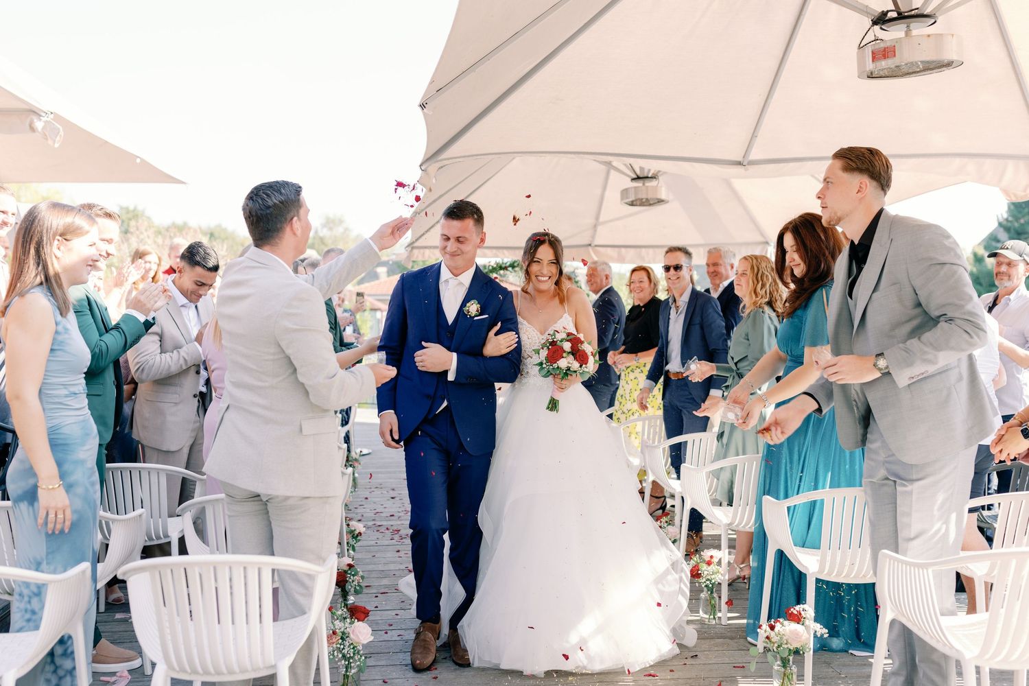 Wedding reception setup with white tents and chairs for outdoor celebration.