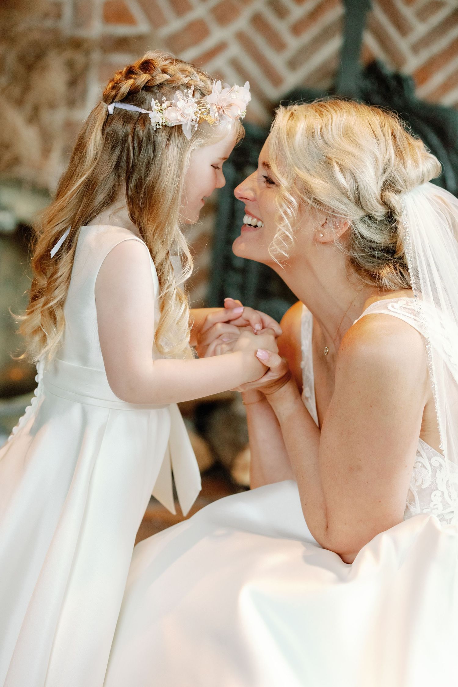 A sequence of candid moments showing two people in white dresses sharing joyful laughter together.