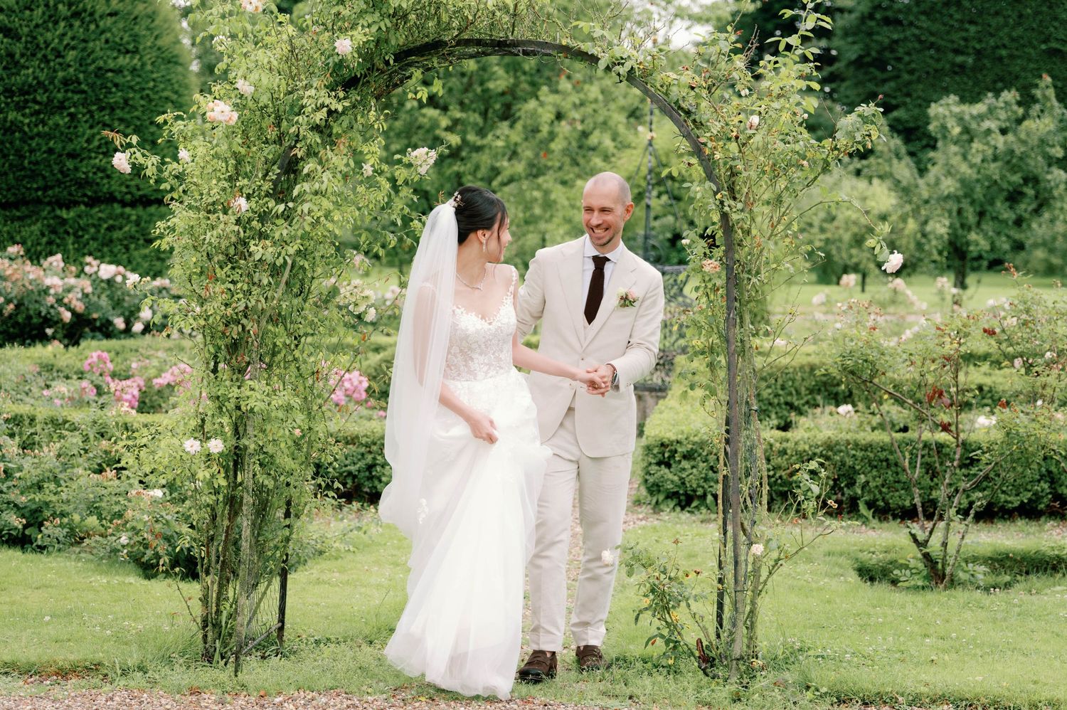 Bride and groom share intimate moments in a lush garden setting during their outdoor wedding celebration.