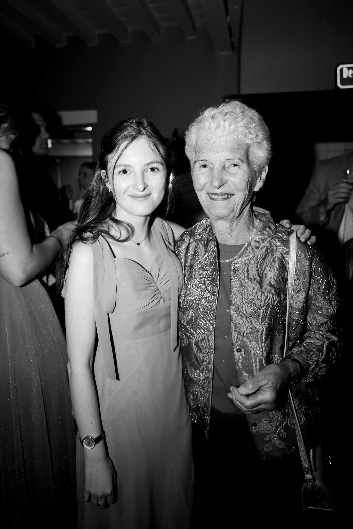 Black and white photo series showing two people posing together at a social gathering in an intimate setting.