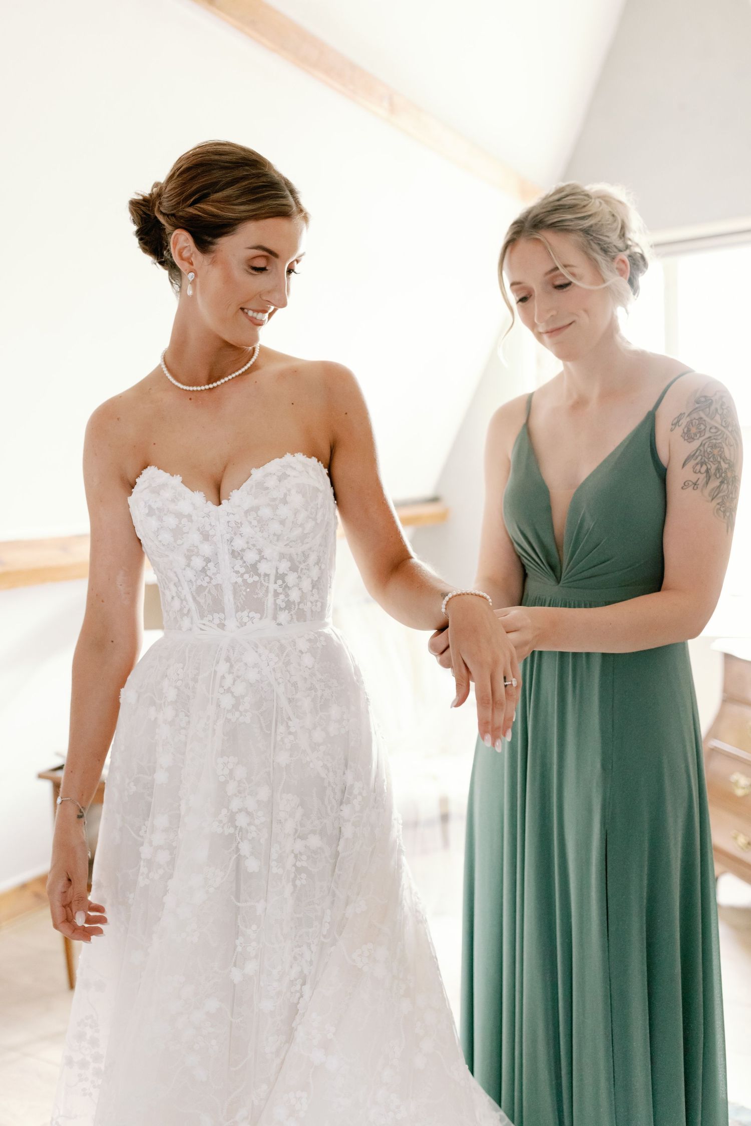 A series of photos showing bridesmaids in sage green dresses helping with a white lace wedding gown.