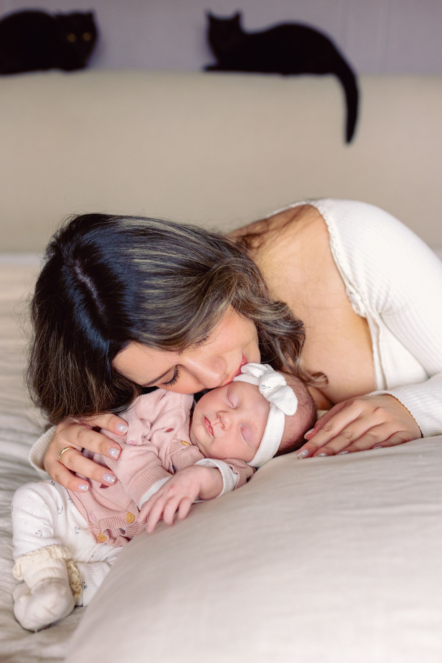 An intimate portrait of a sleeping baby with parent lying close by.