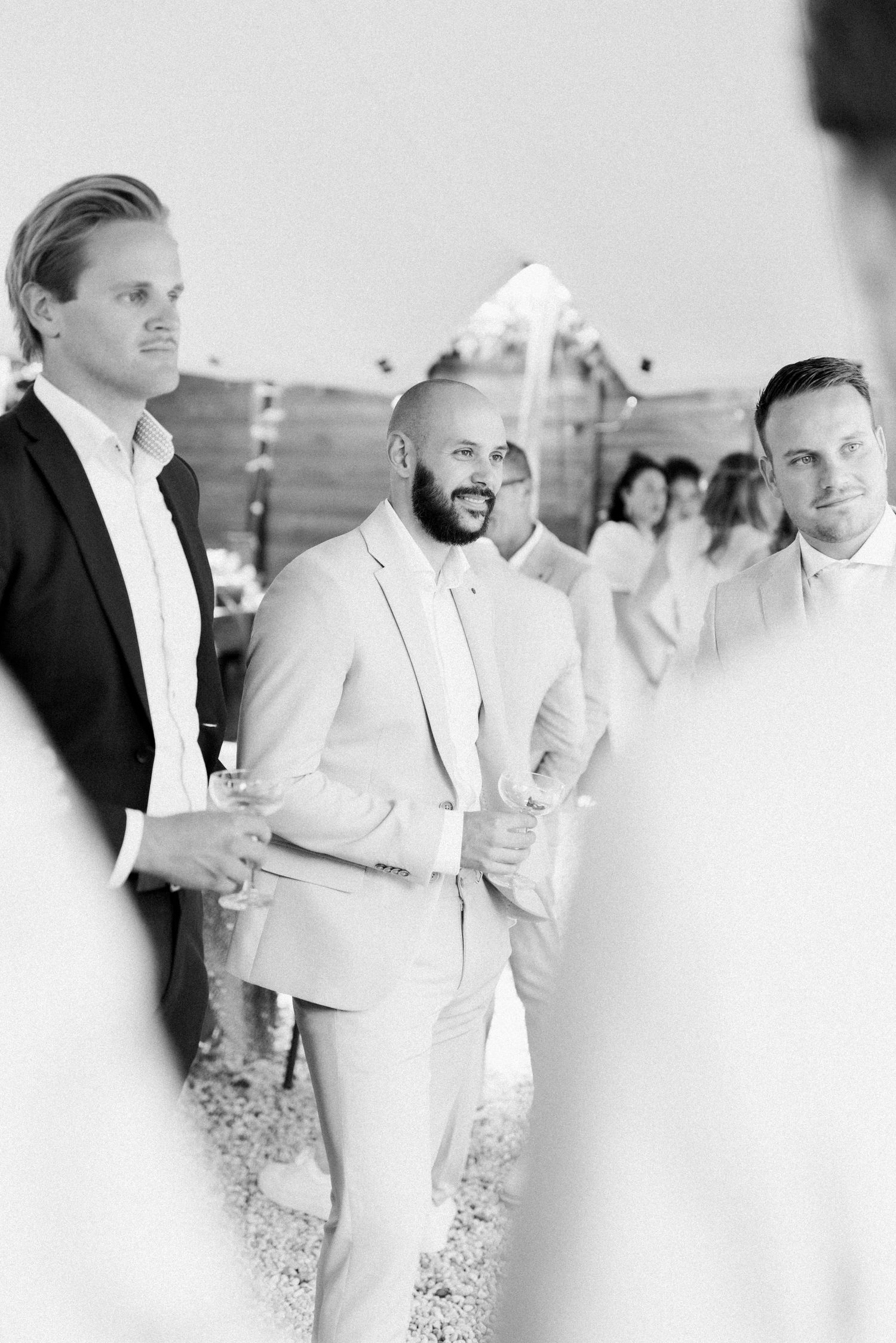 A group of people in white formal attire gathered together at an elegant event.
