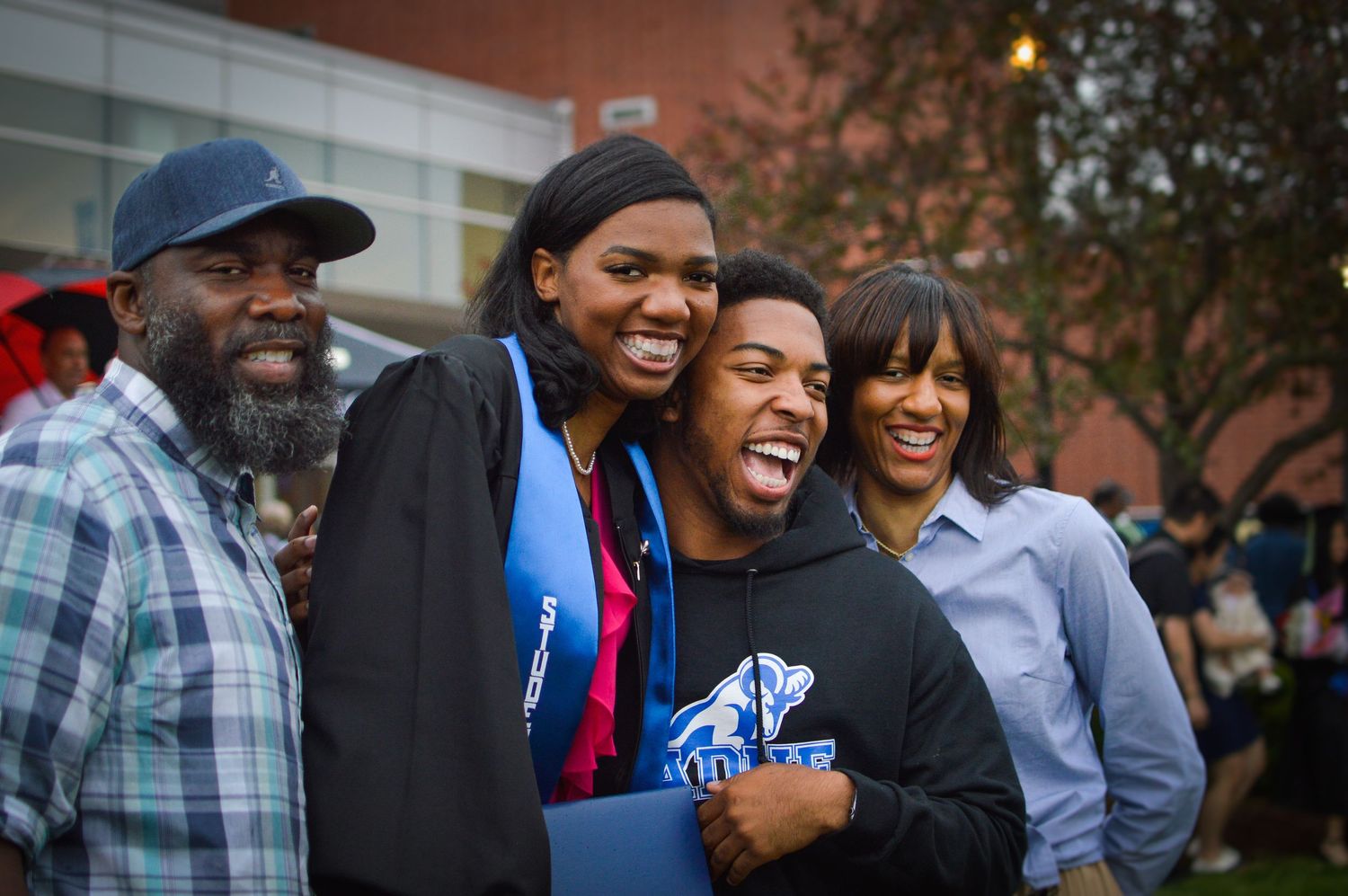 A group of people share joyful laughter together while gathered outdoors.