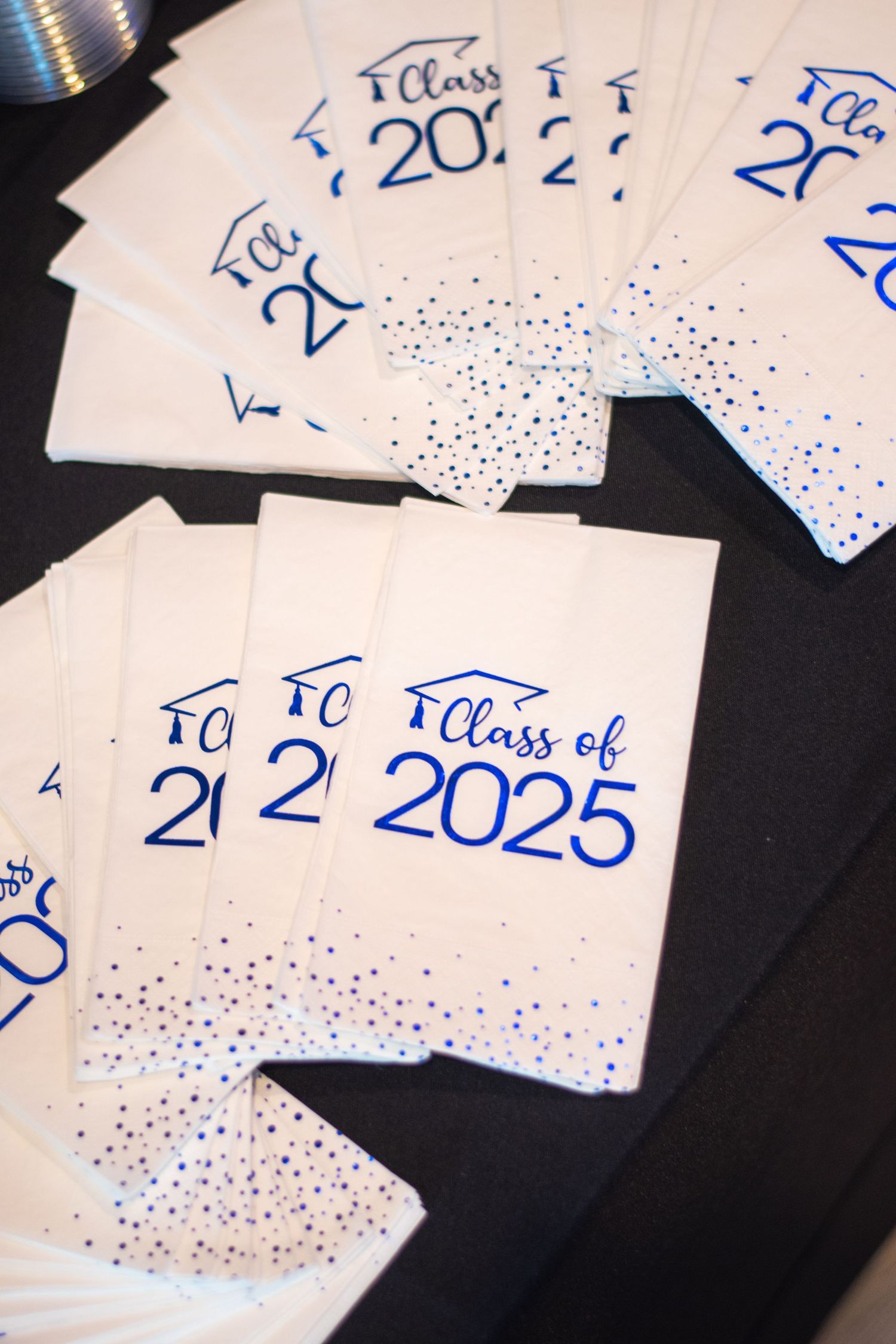 Multiple handwritten cards with dates and numbers in blue ink scattered on a dark surface.