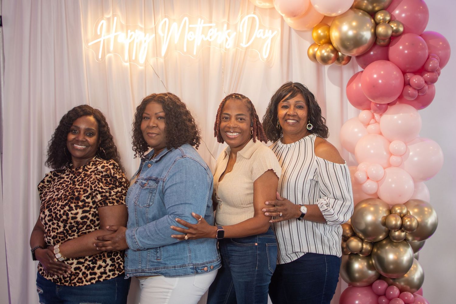Party scene with pink and gold balloon decorations and neon signage.