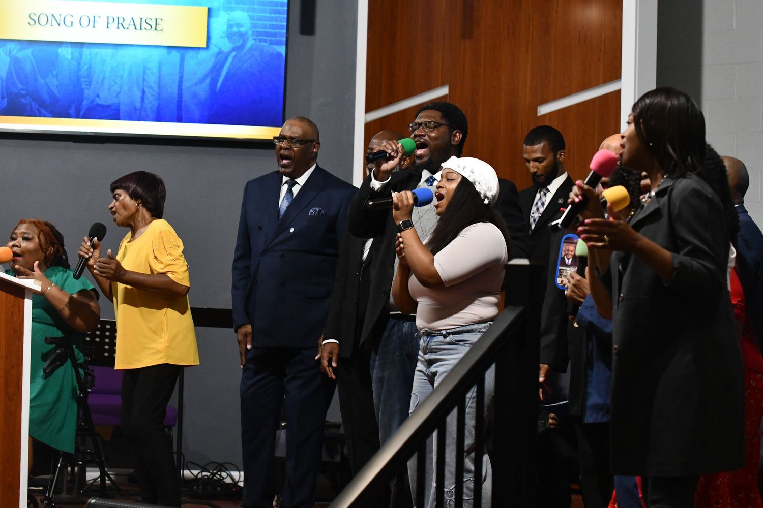 A group of people dance and celebrate in what appears to be a church or community gathering space.