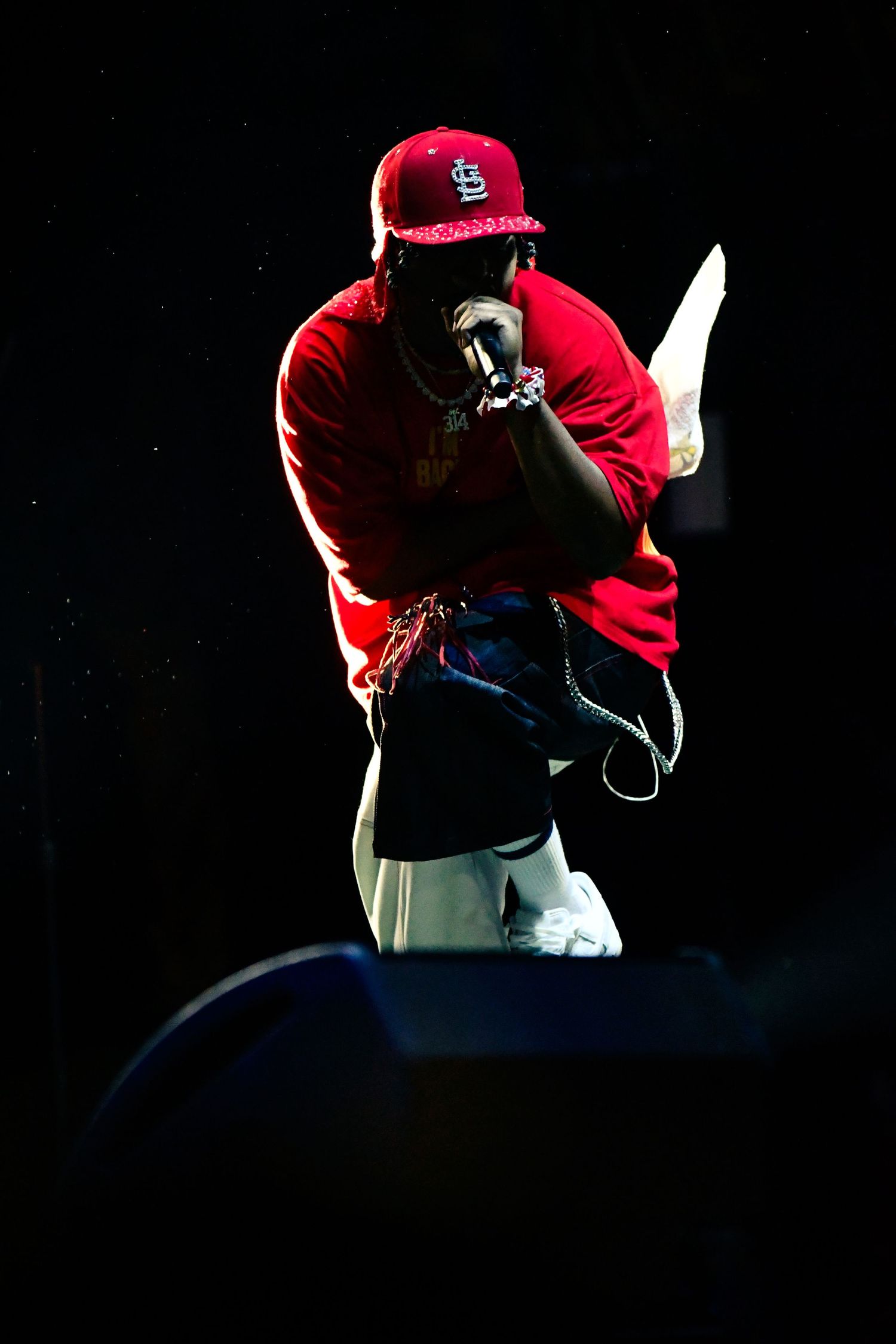 A baseball player in a red St. Louis Cardinals cap shown in a sequence of dark silhouetted profile shots.