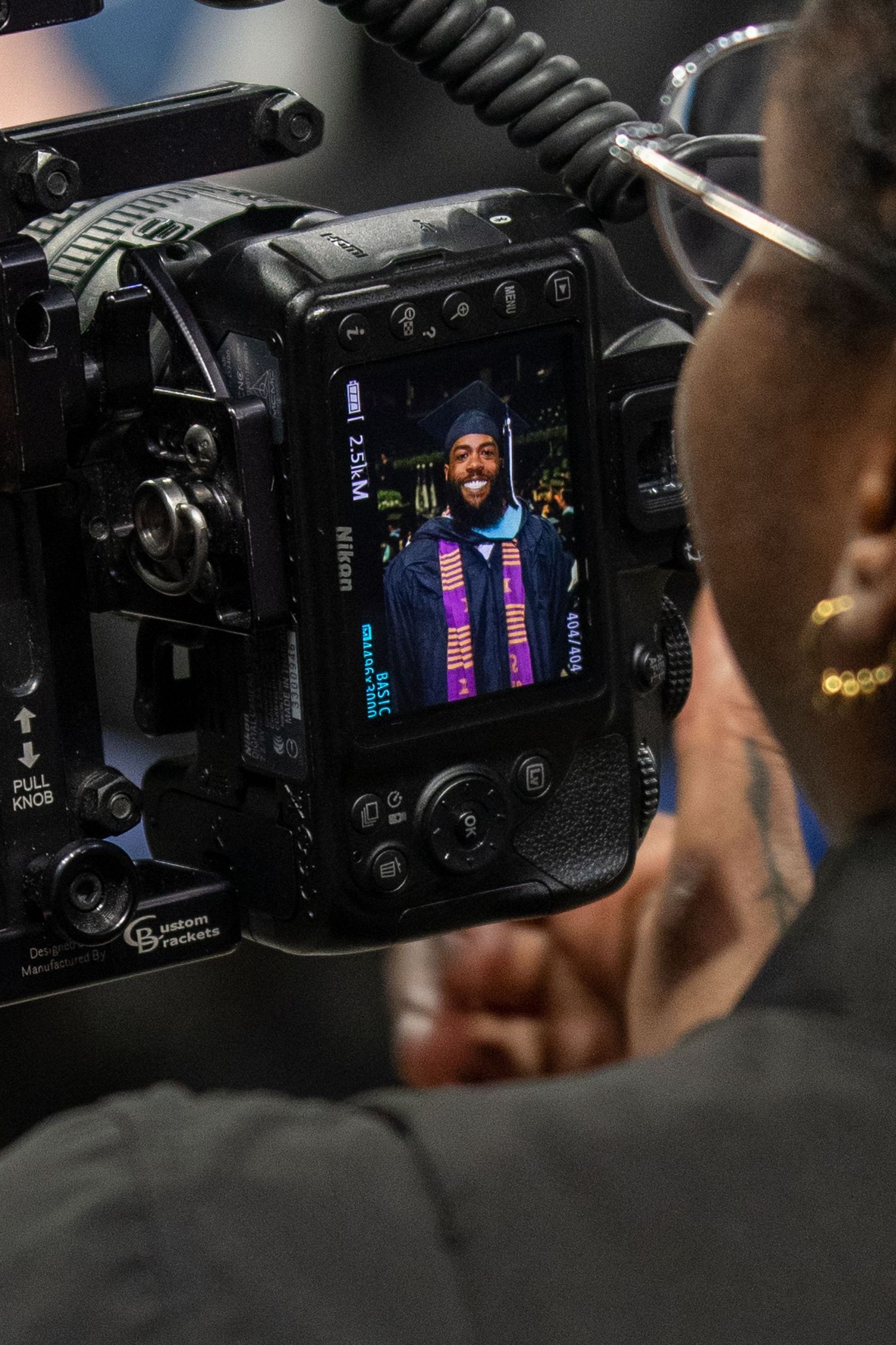 Camera display screen shows graduate in regalia during photo session.