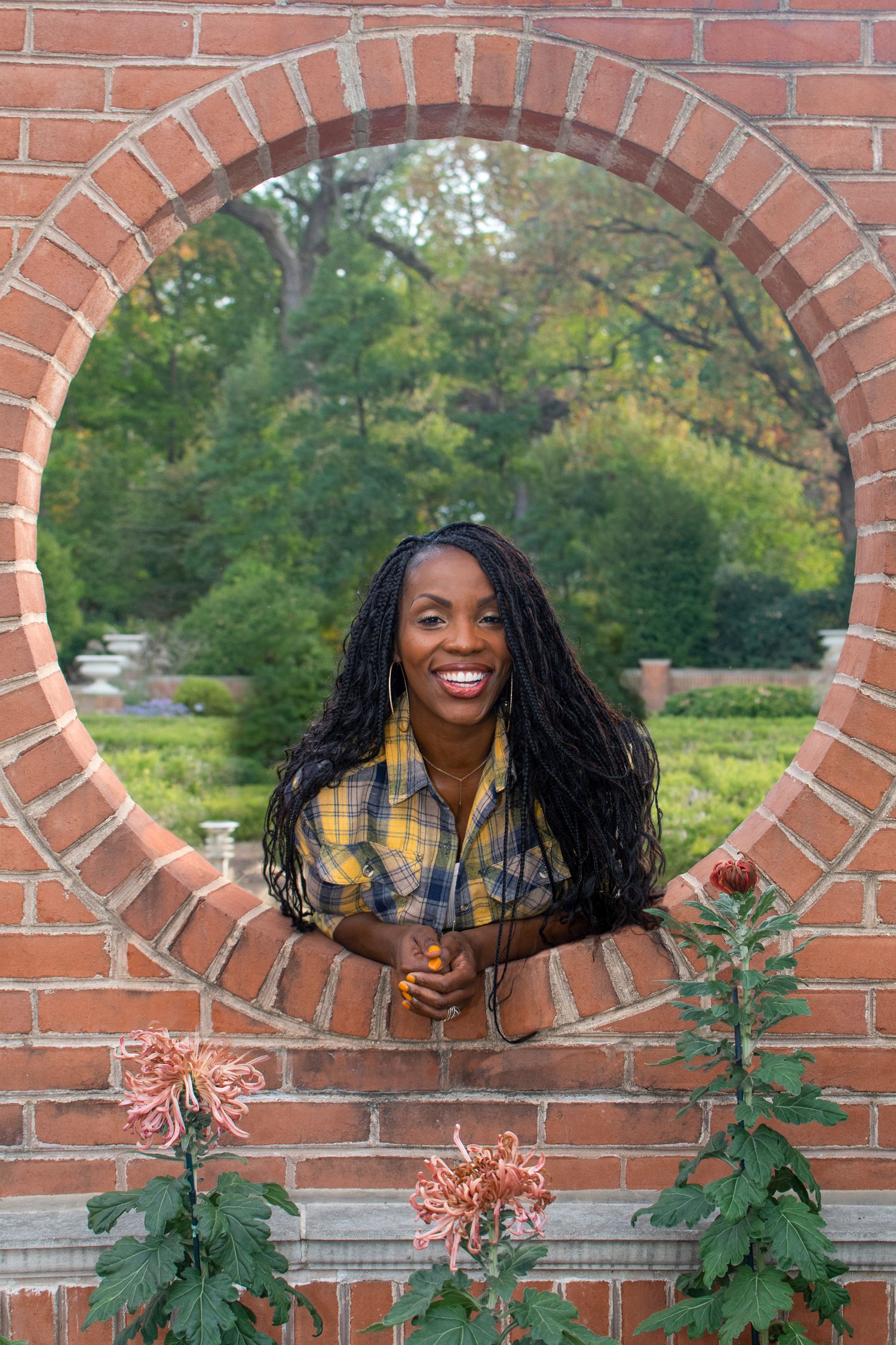 Playful poses captured through architectural brick openings in an outdoor setting.
