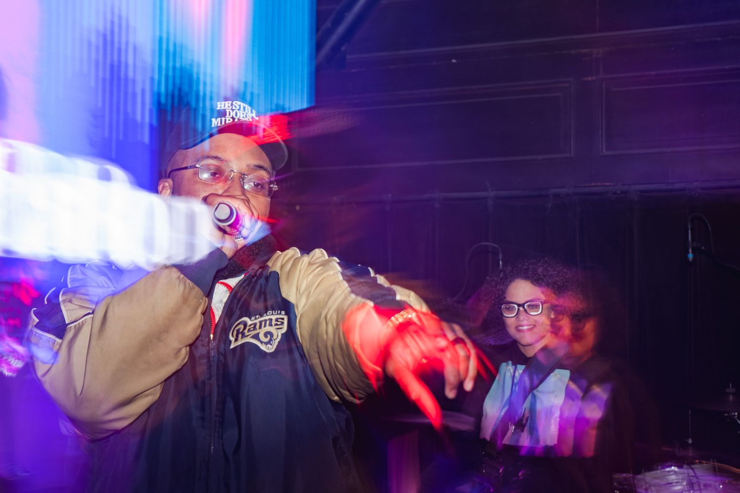 A group of people dancing and having fun at a nightclub with colorful blue and red lighting.