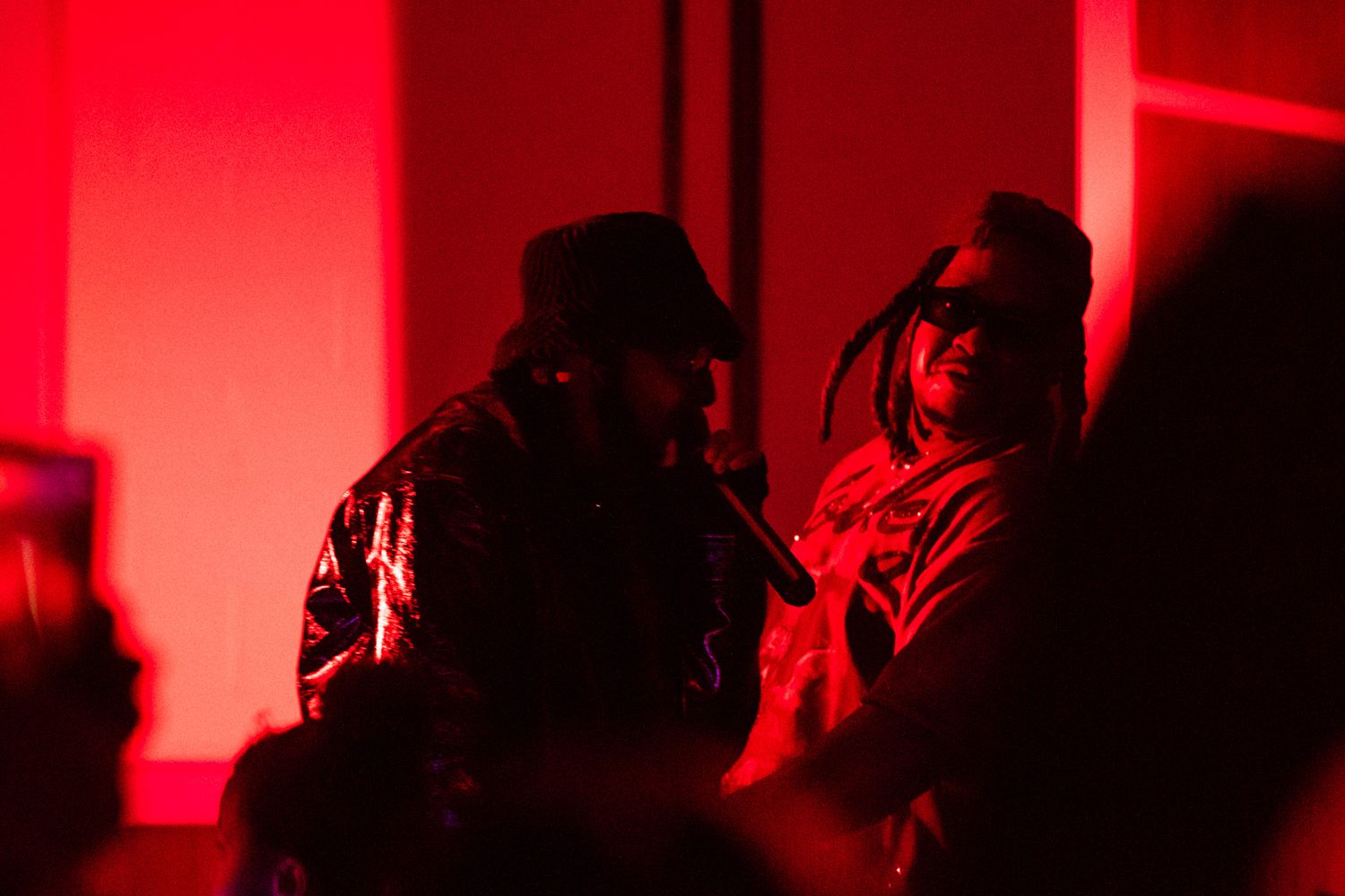 Silhouettes of people dancing in a club with dramatic red lighting and smoke effects.
