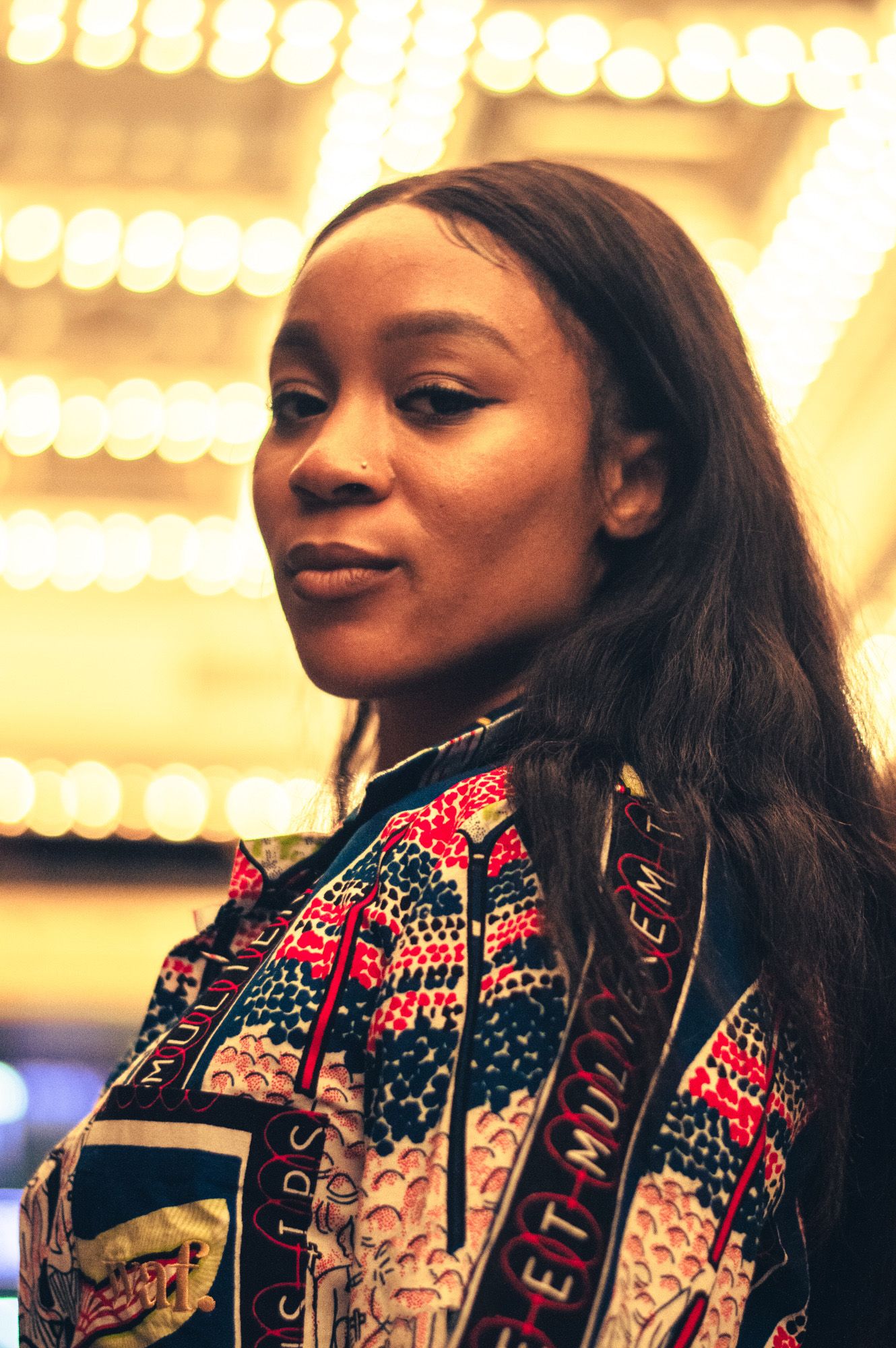 Artistic portrait sequence showing vibrant traditional patterned clothing against warm glowing lights in background.