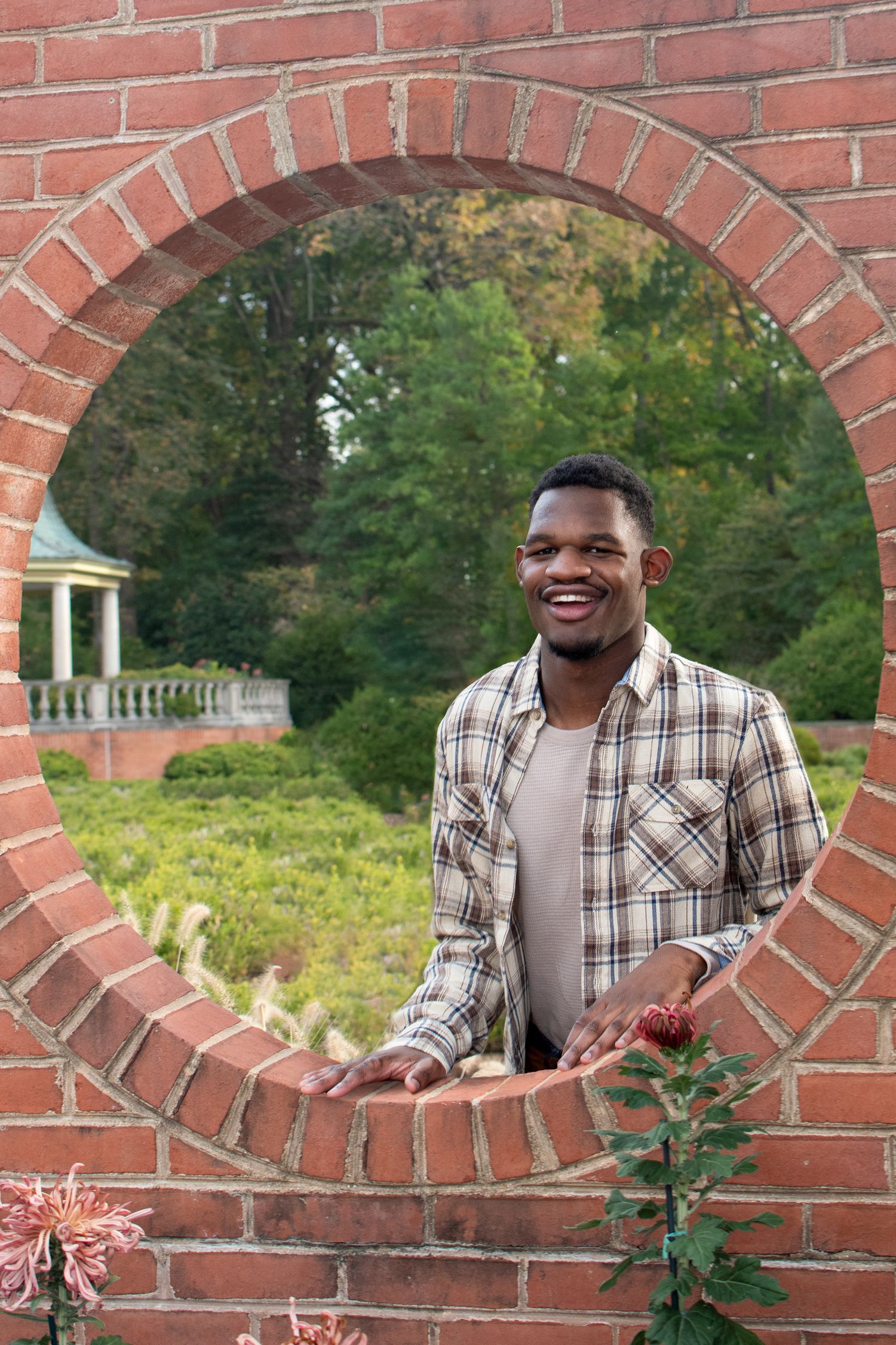 Joyful expressions captured through brick archways in a garden landscape.