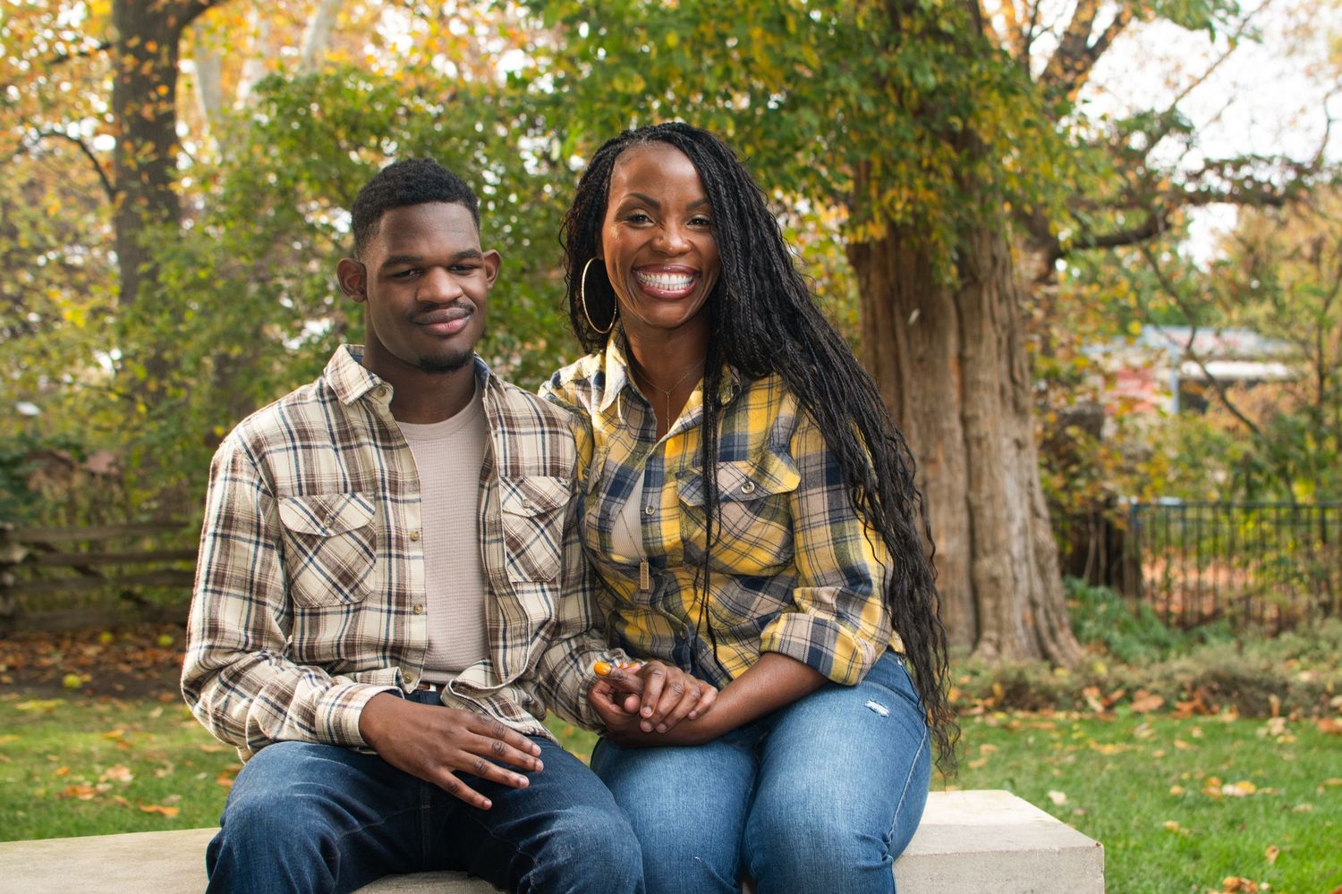 Natural outdoor portrait session with fall foliage and brick architecture in the background.