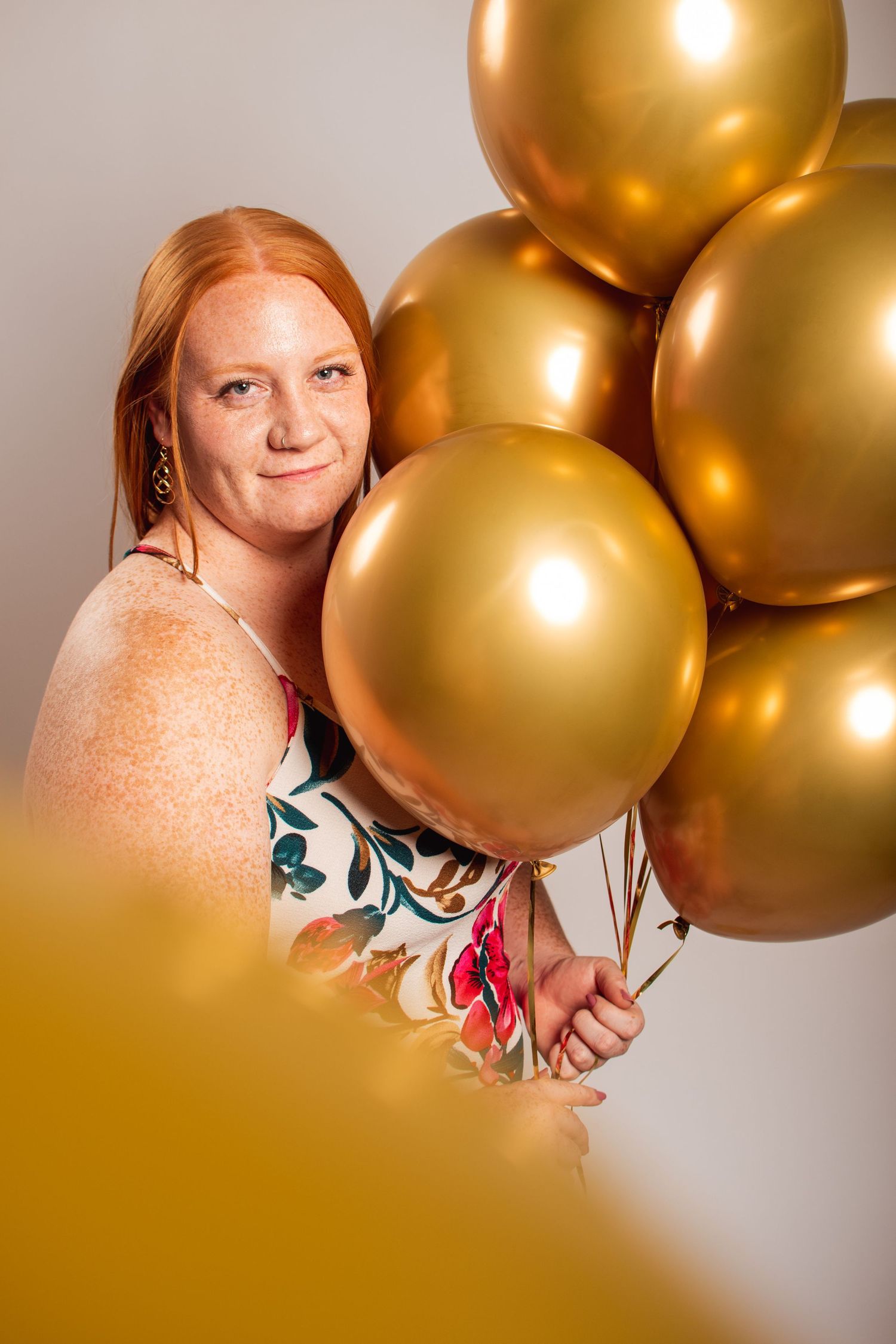 Gold chrome balloons create a luxurious backdrop against a neutral background in a celebratory setting.