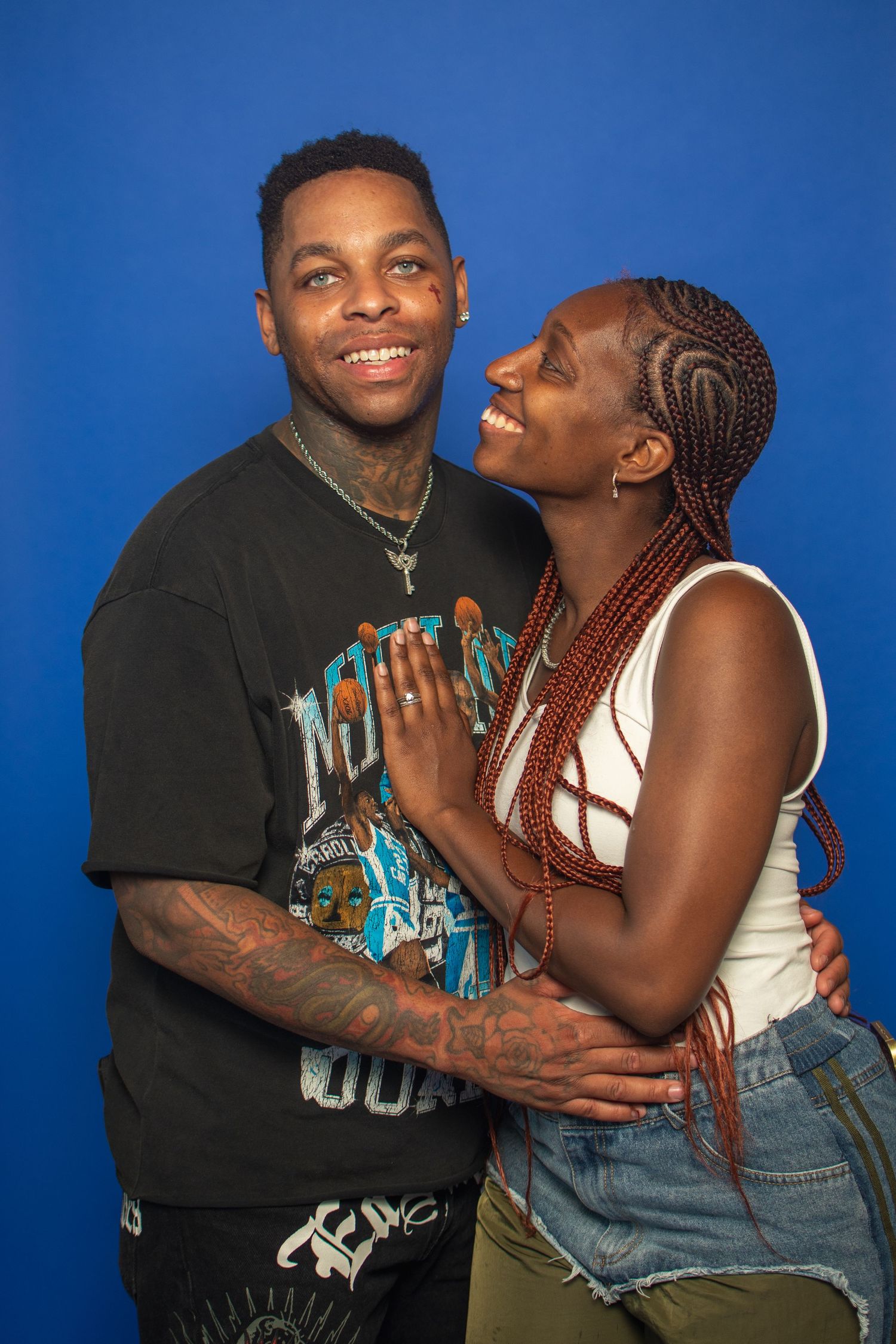 Two people in casual clothing share affectionate moments against a blue background in a photo series.