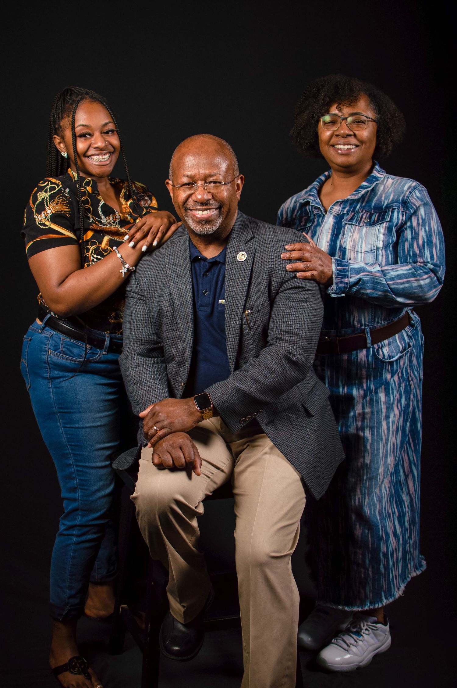 Studio portrait series showing a couple in coordinated blue and gray outfits posing together against a black background.