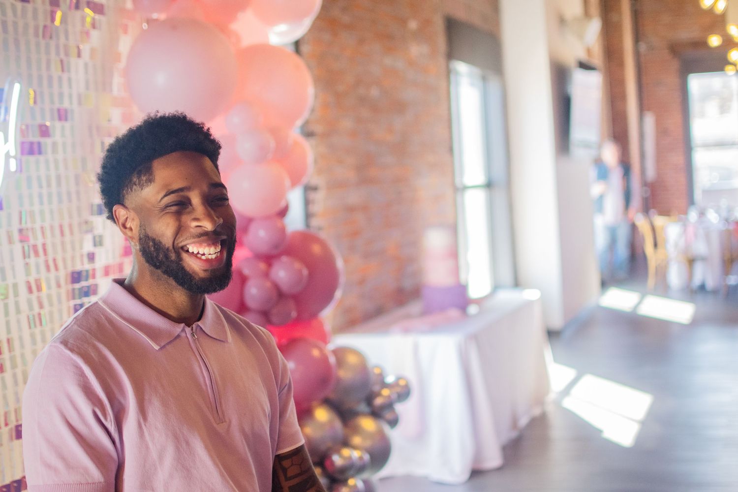 black man portrait in front of pink balloons