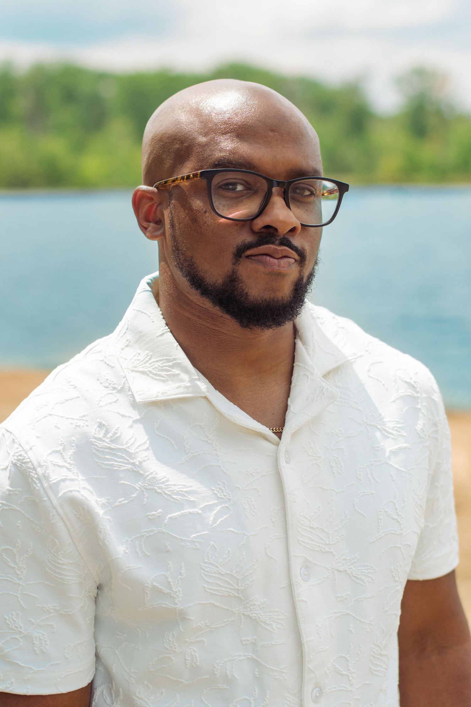 A man in glasses and white shirt poses by a waterfront in a series of connected profile photos.