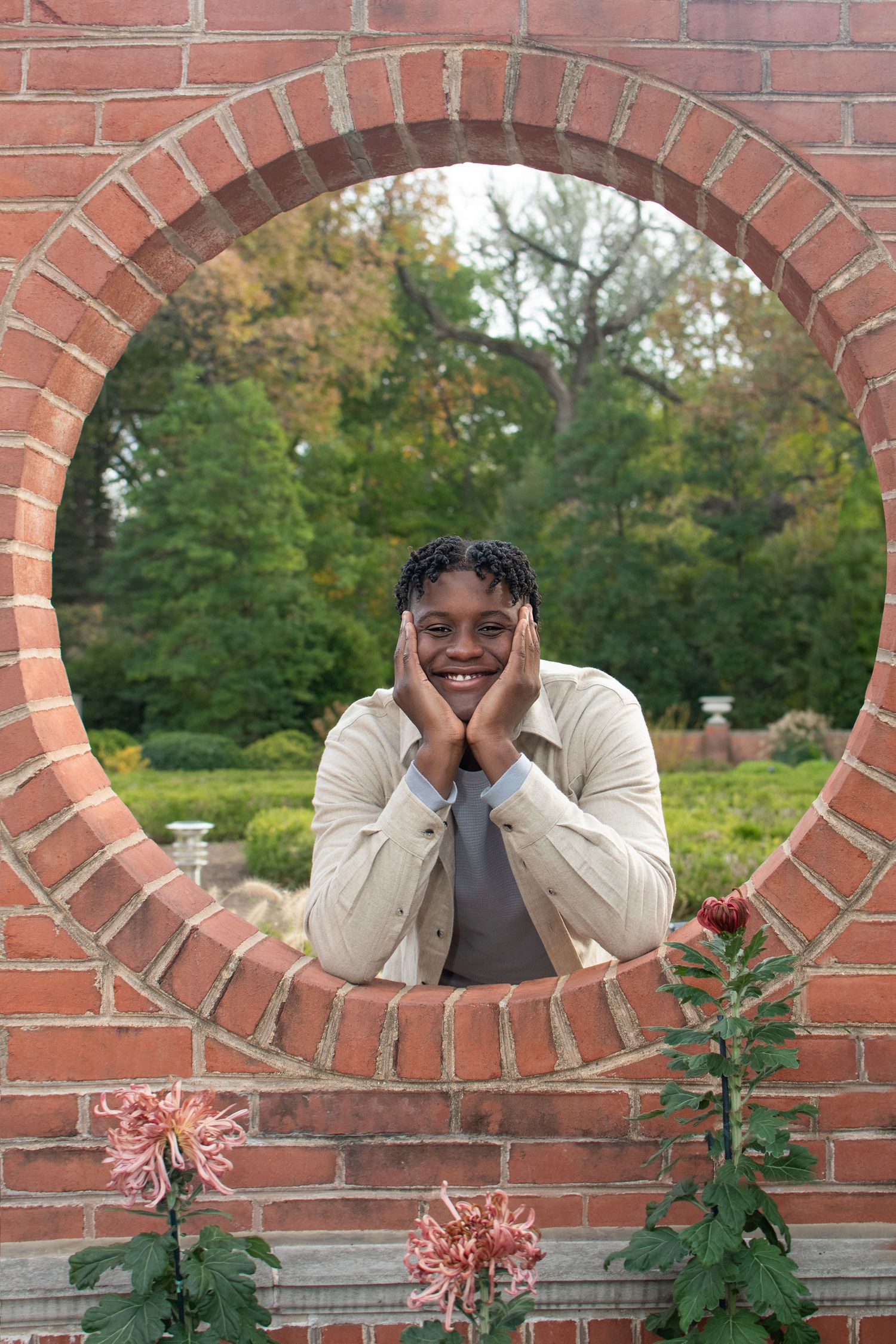 Creative portraits taken through decorative brick archways in a garden setting.