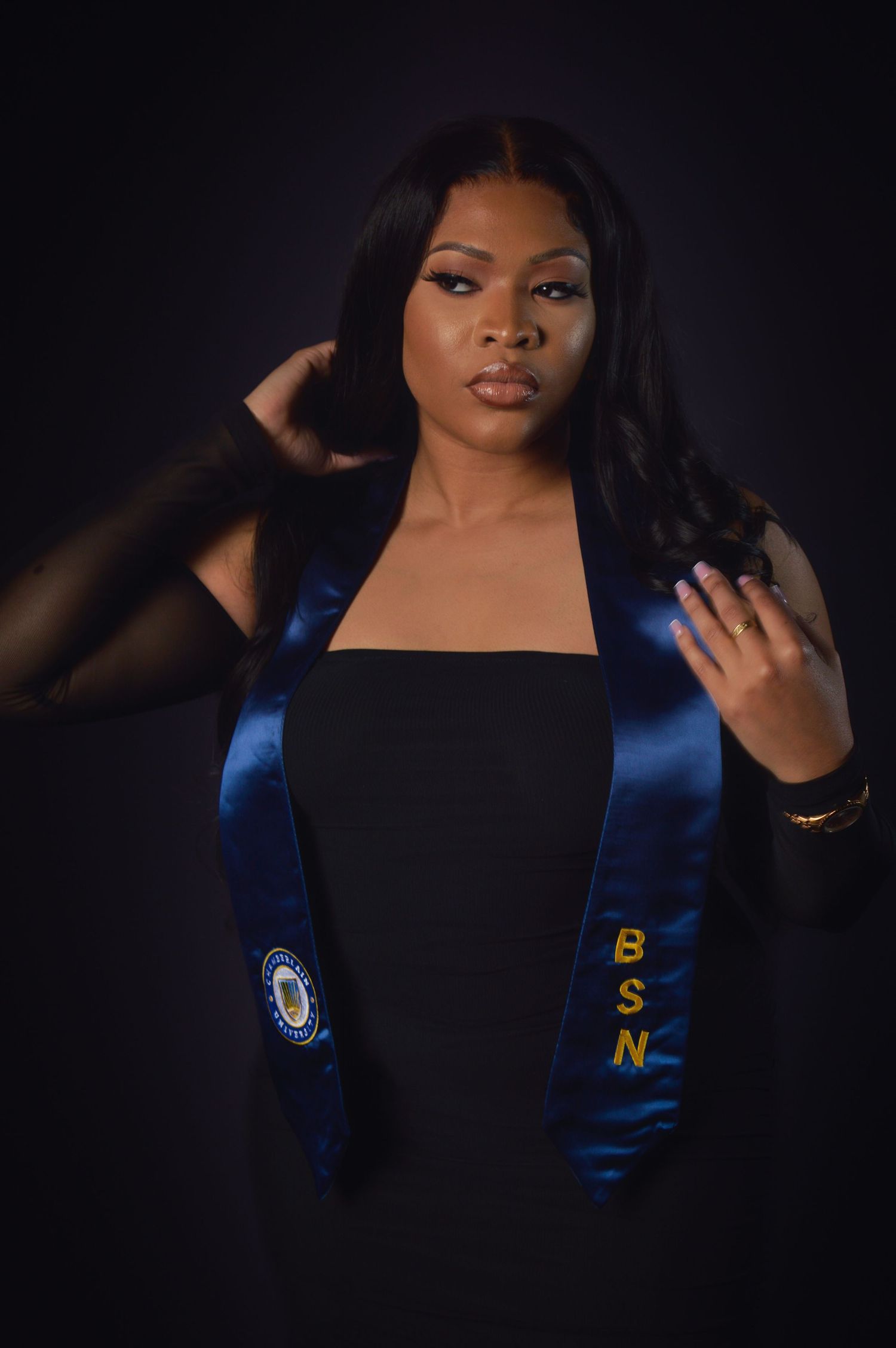 Graduation portrait with blue stole against black background showing dramatic lighting and poses.