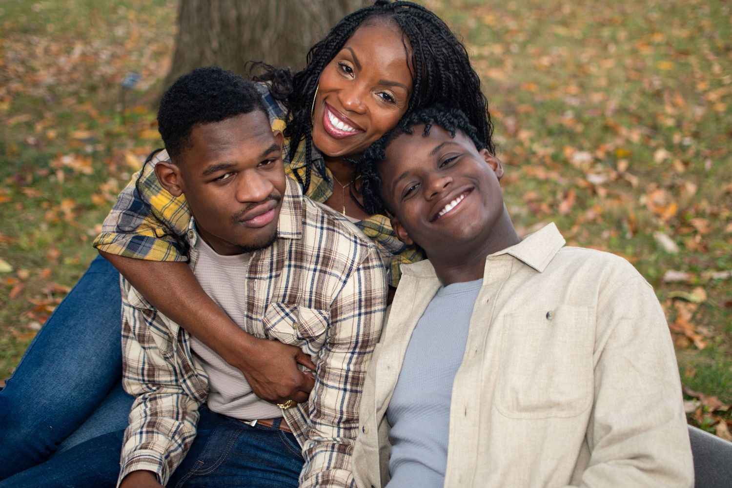 Candid outdoor family photography session with coordinated outfits against autumn scenery.