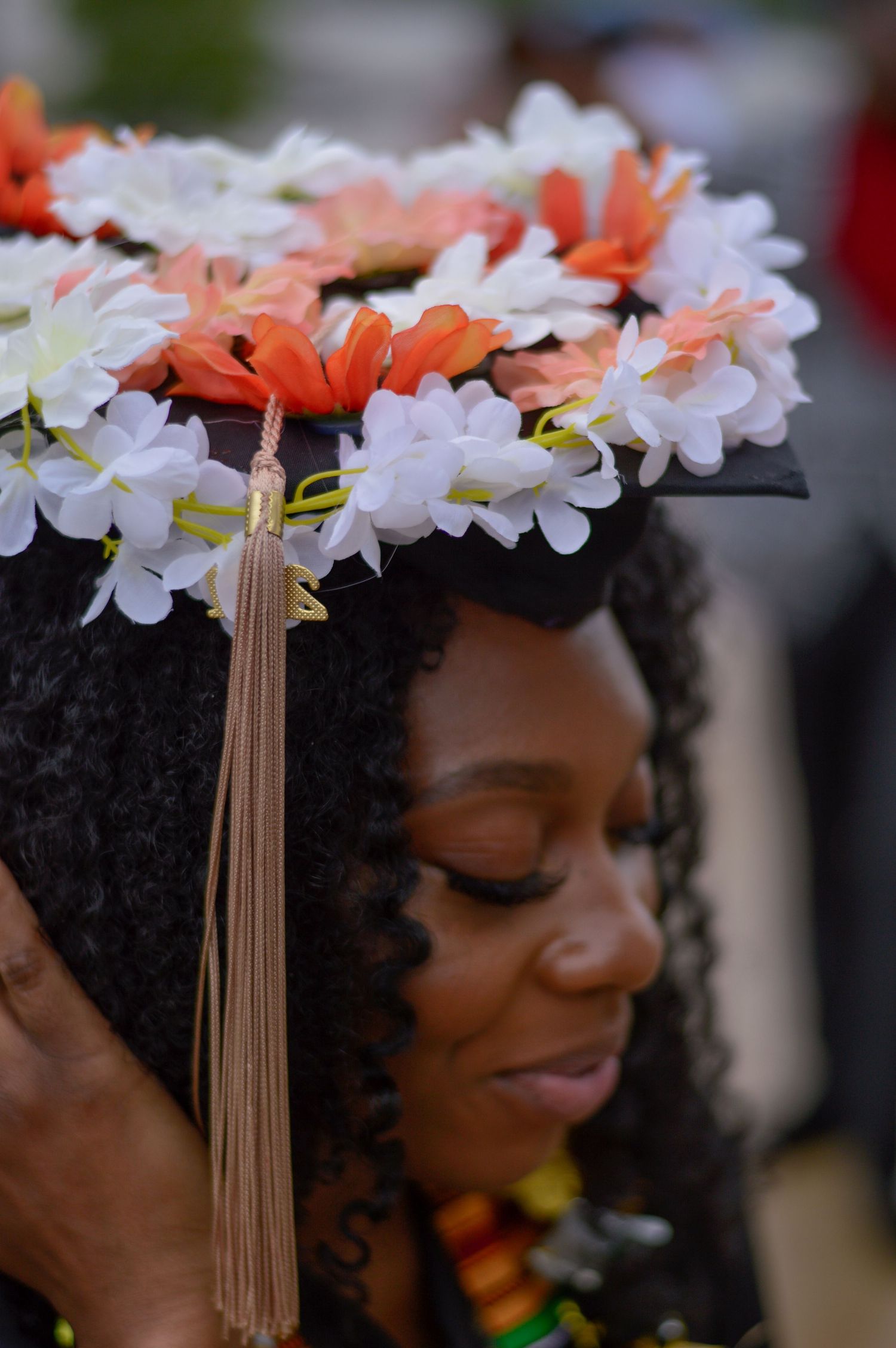 A series of close-up photos showing a person wearing white and coral flowers in their hair with gold tassels.