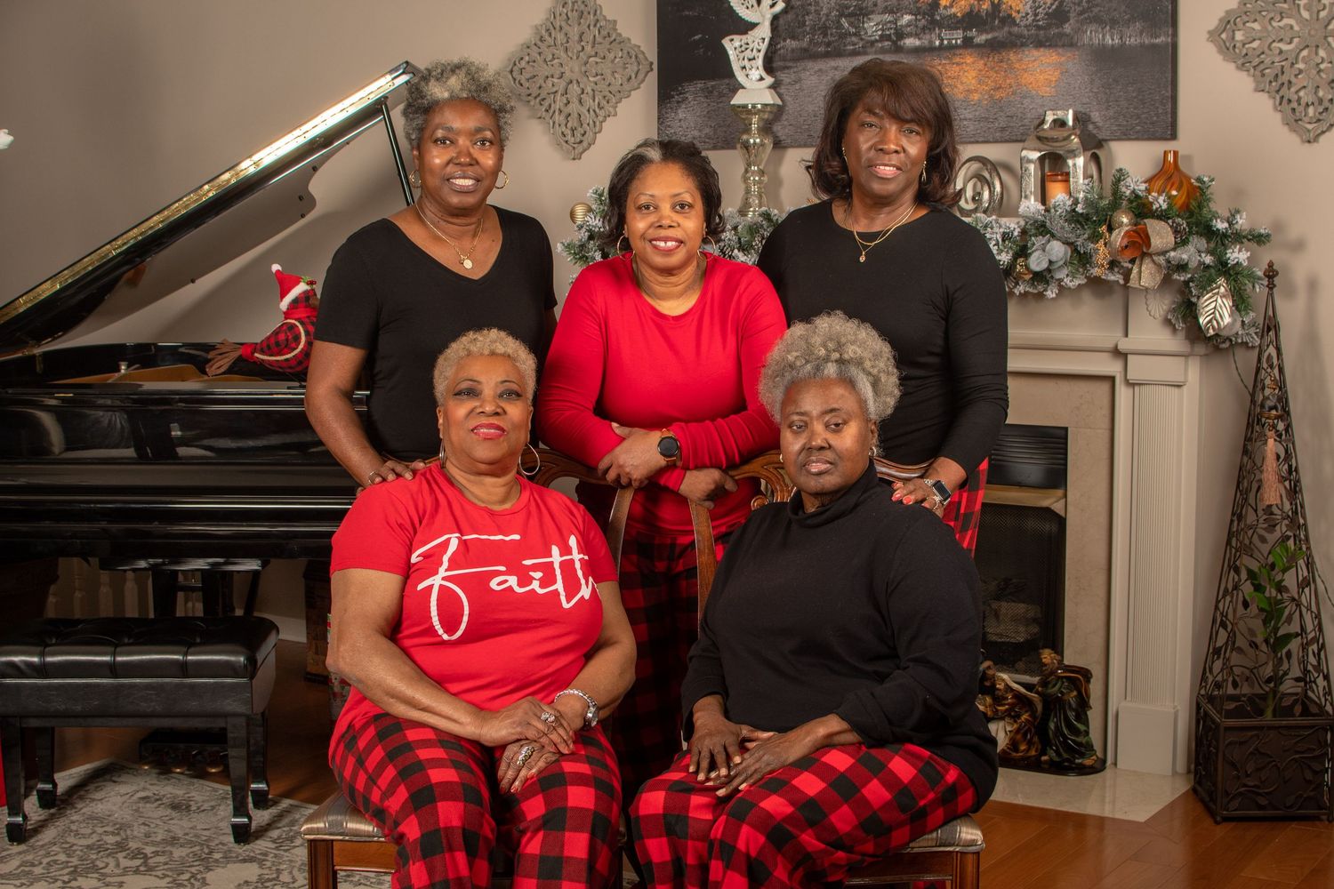 Family members wearing matching red and plaid outfits pose together in a cozy holiday setting.