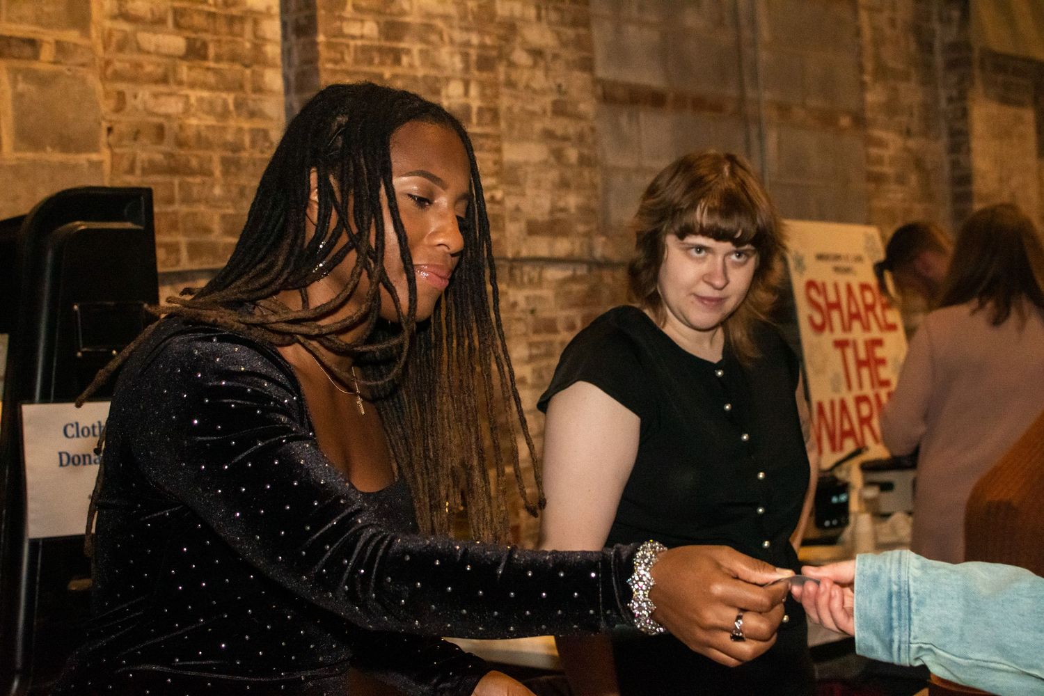 Group of people gathered at a brick-walled venue during what appears to be a social event or party.
