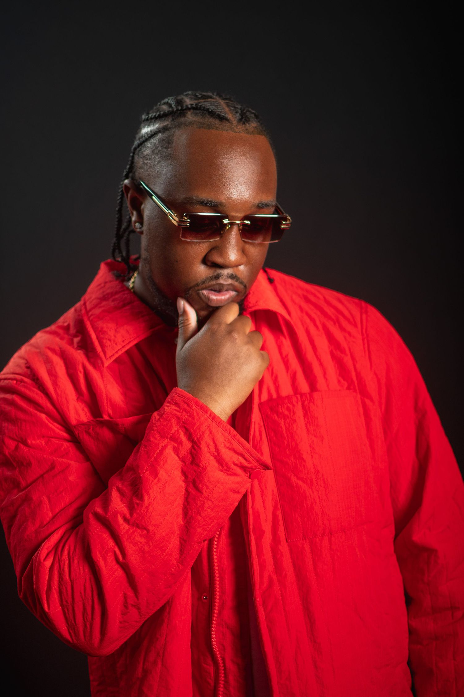 A person in a bright red jacket and sunglasses poses against a dark background in a series of similar shots.
