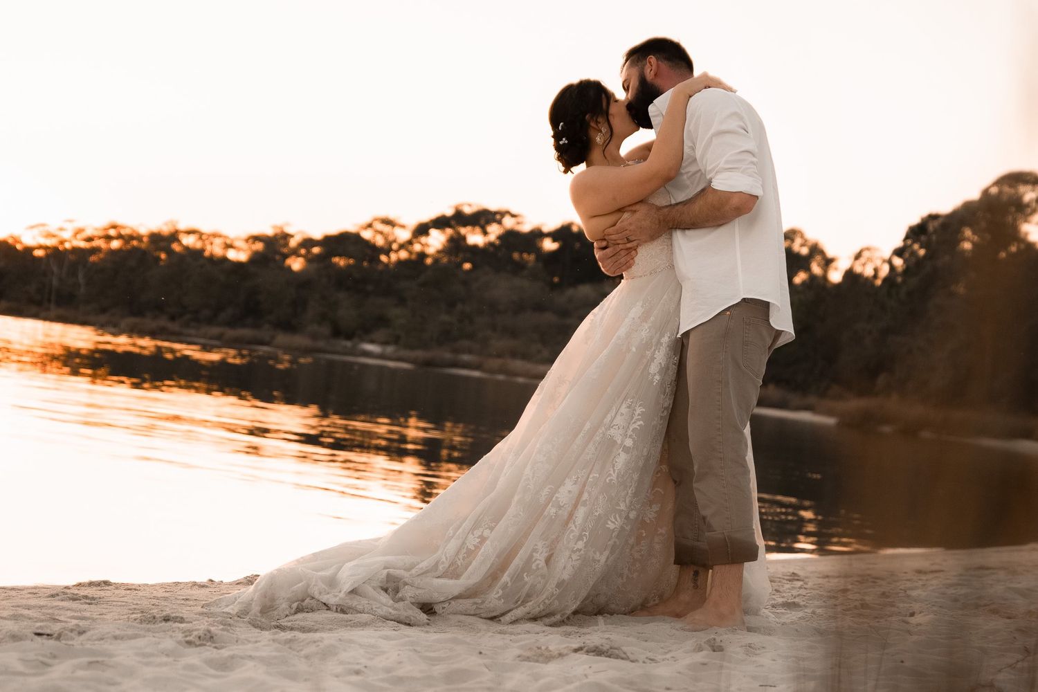 Emotional beach wedding moment captured with dreamy light and gentle waves