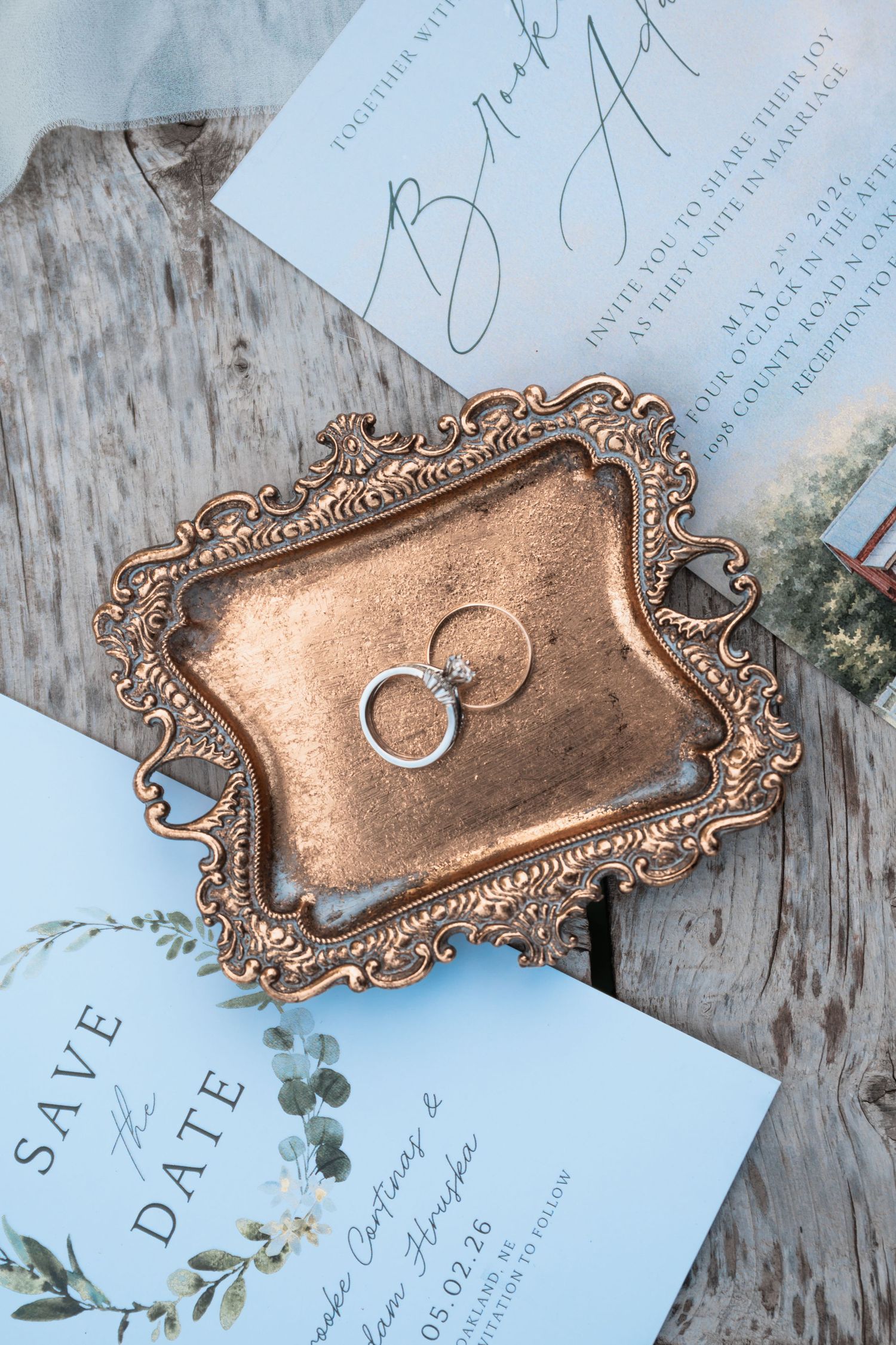 Elegant wedding rings and invitation suite styled together with soft romantic details