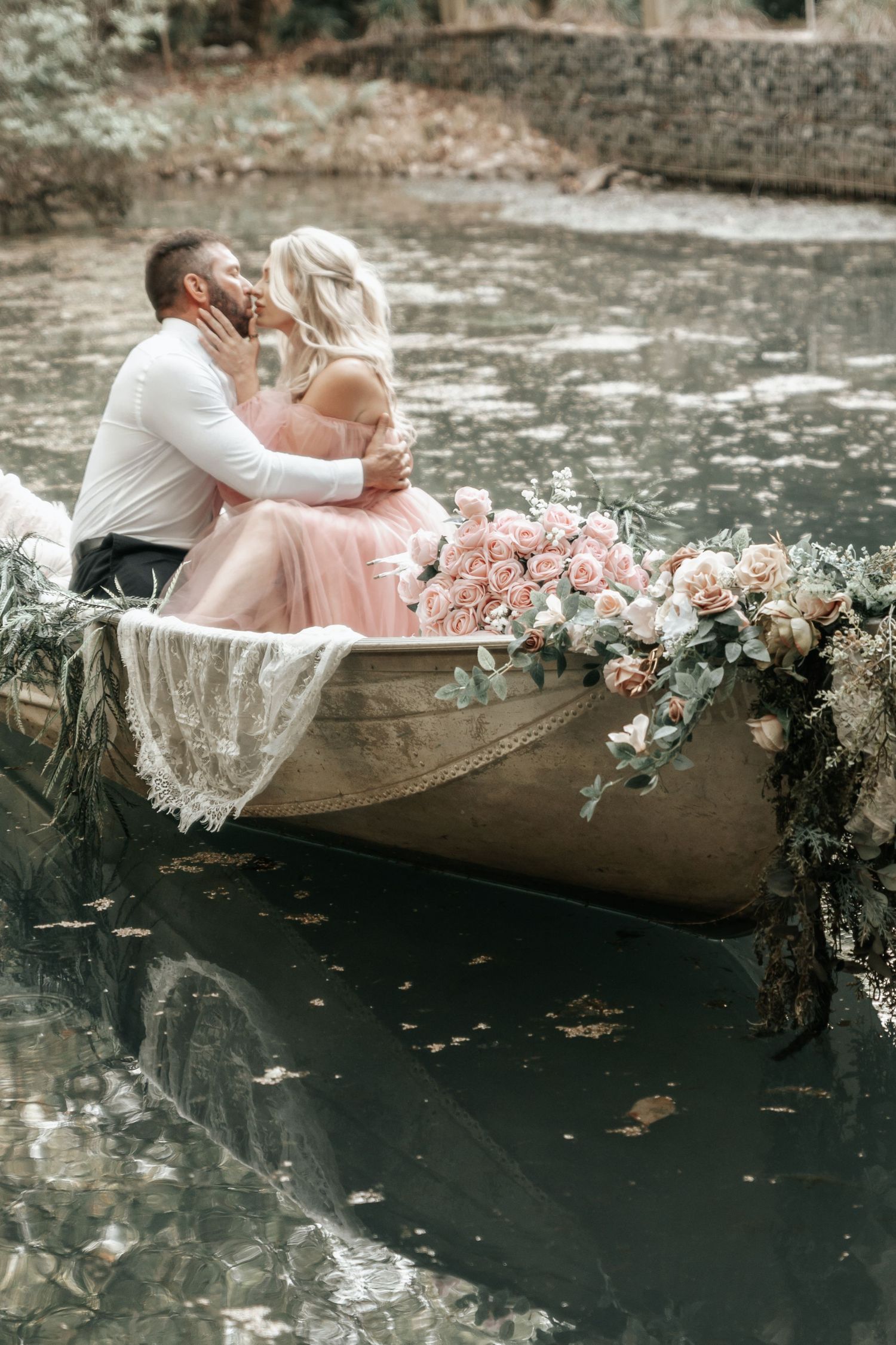 Couple cuddled together on a dreamy boat surrounded by calm coastal waters