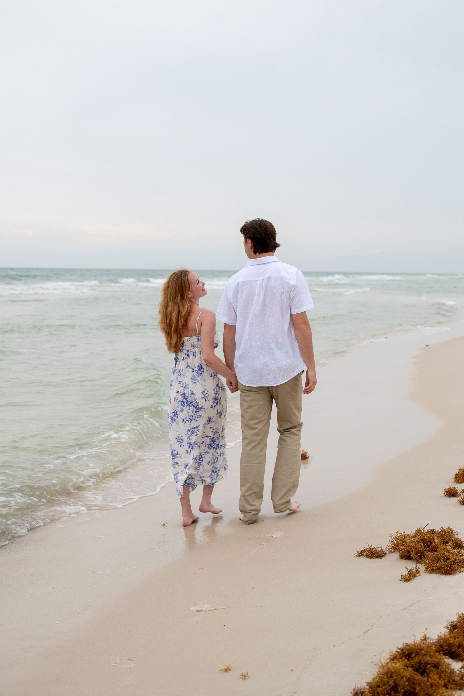 Couple embracing after romantic beach proposal under warm evening light