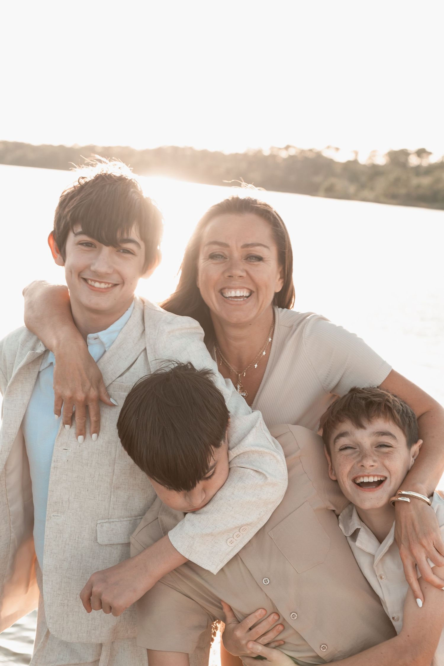 Candid lifestyle family portrait of laughter and movement on the beach at golden hour