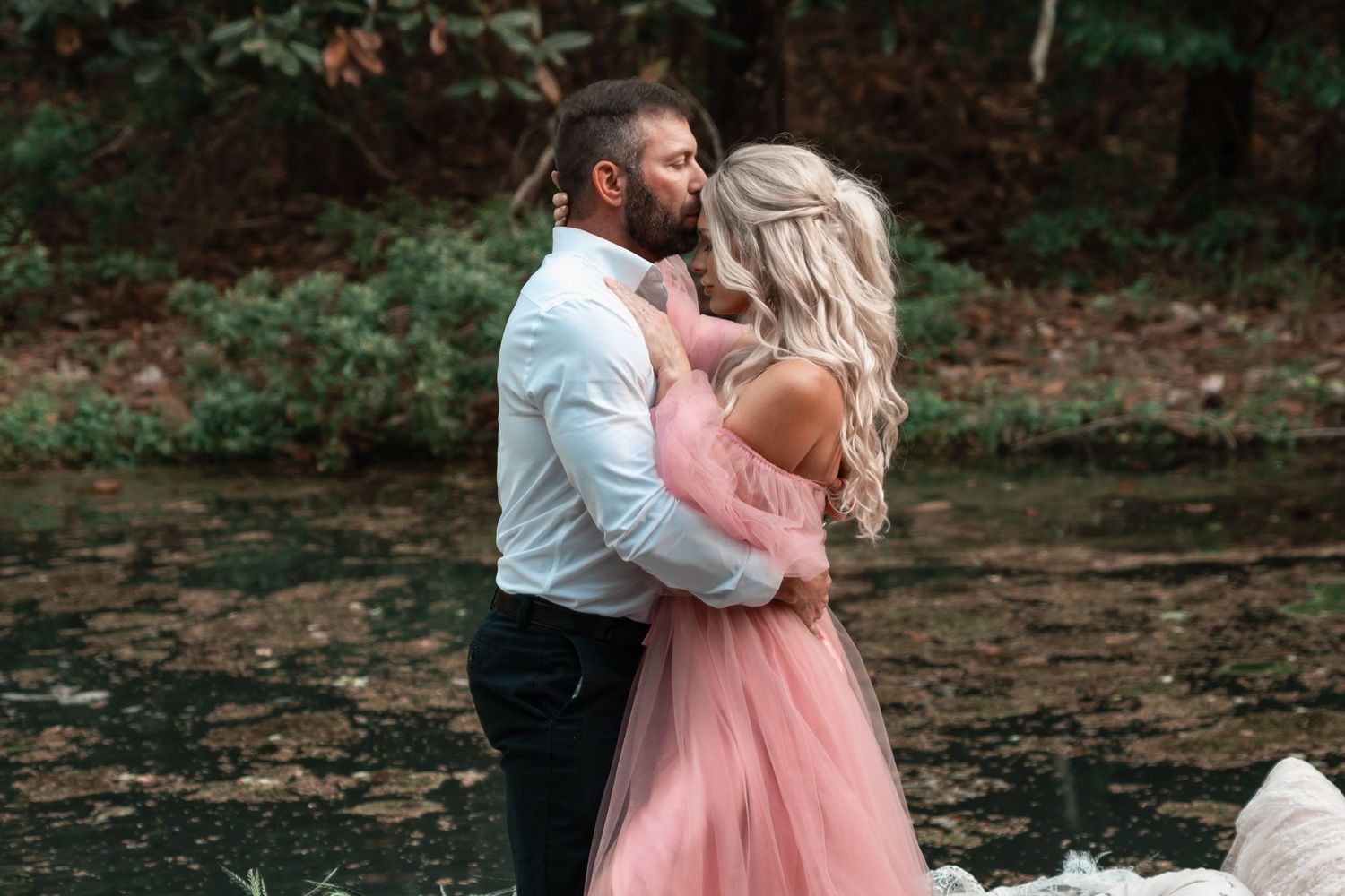 Moody coastal couples session with romantic movement and soft sunset light