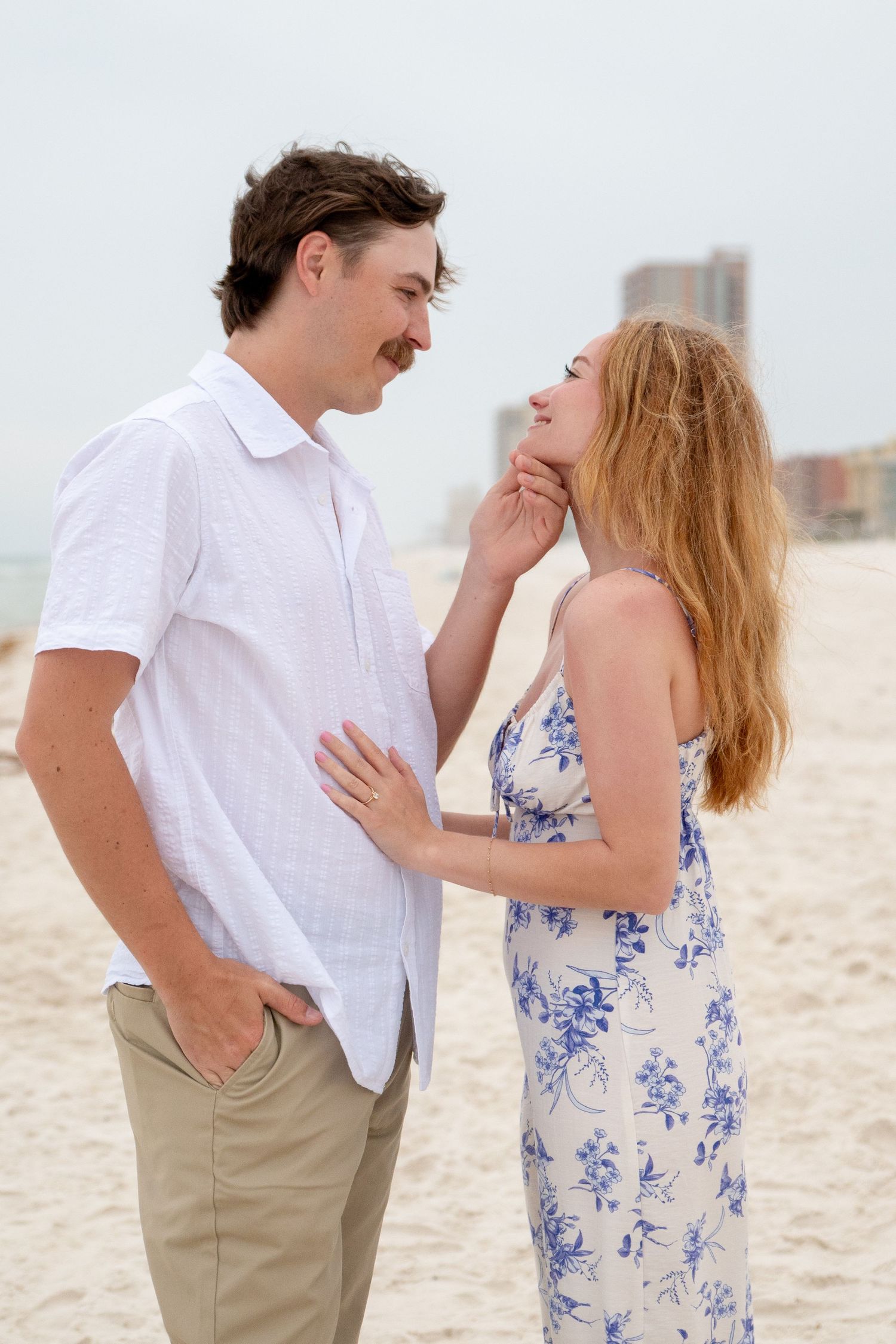 Romantic beach proposal captured at sunset on the Gulf Coast with glowing golden light