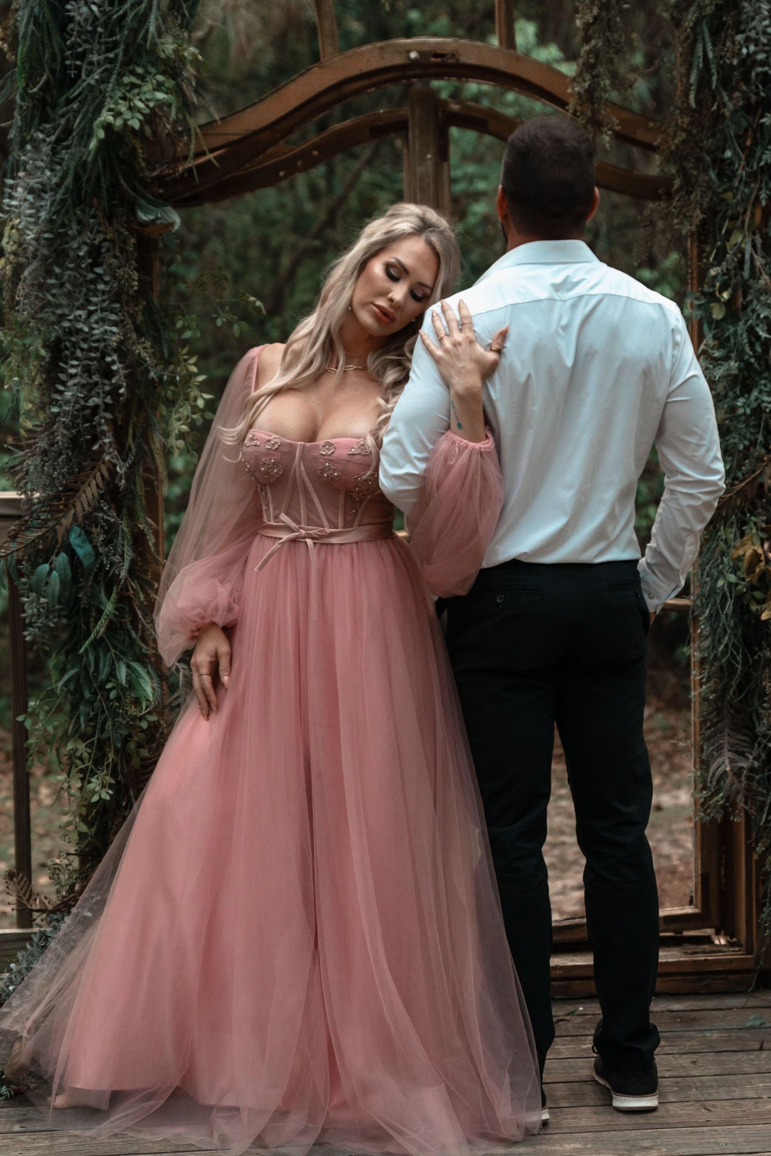 Romantic couple embracing during moody sunset portrait session with flowing gown